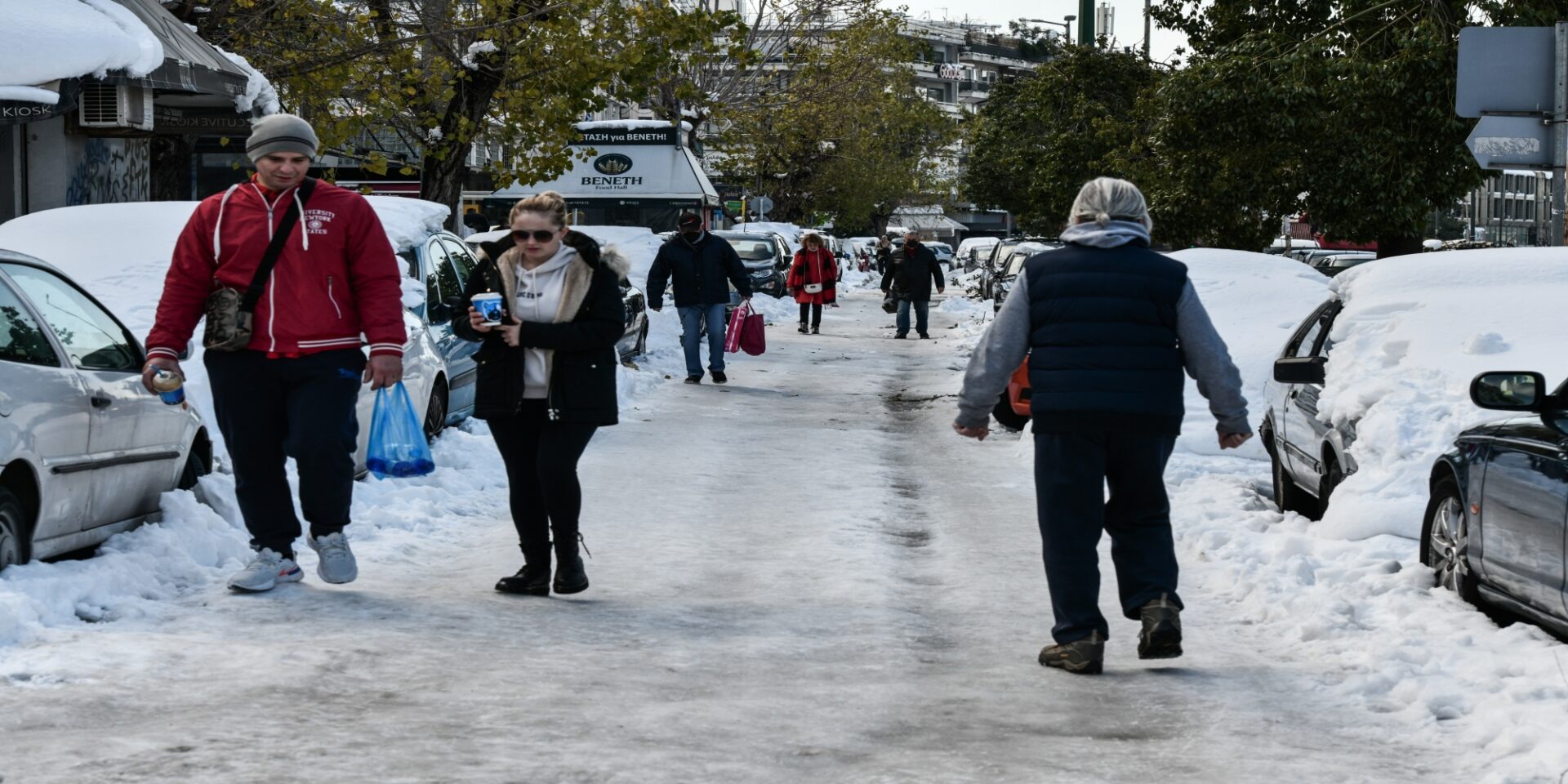 Πολίτες περπατούν στο χιόνι στην περιοχή του Παπάγου