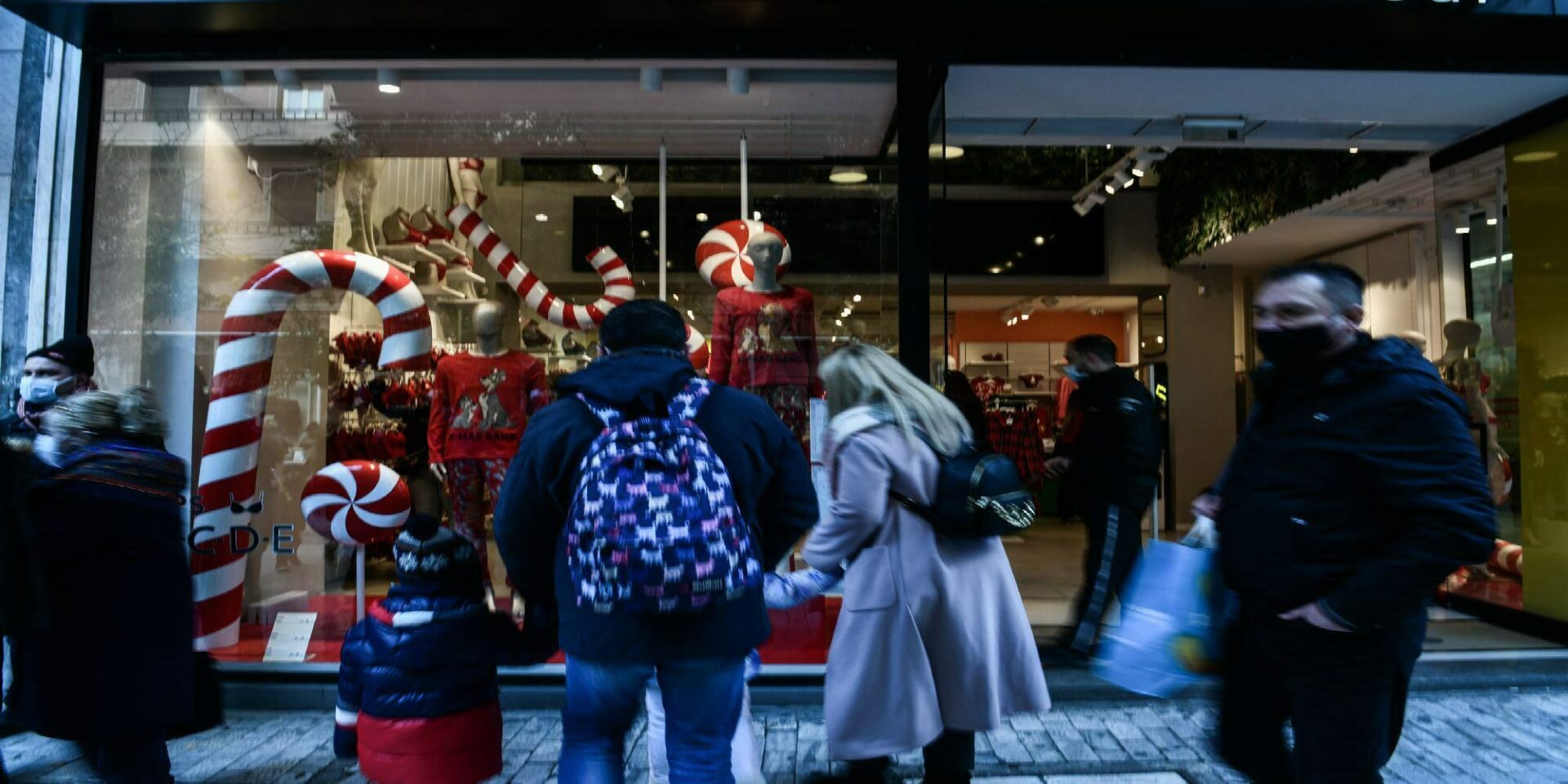 Καταναλωτές κάνουν τις χριστουγεννιάτικες αγορές τους σε καταστήματα στην οδό Ερμού