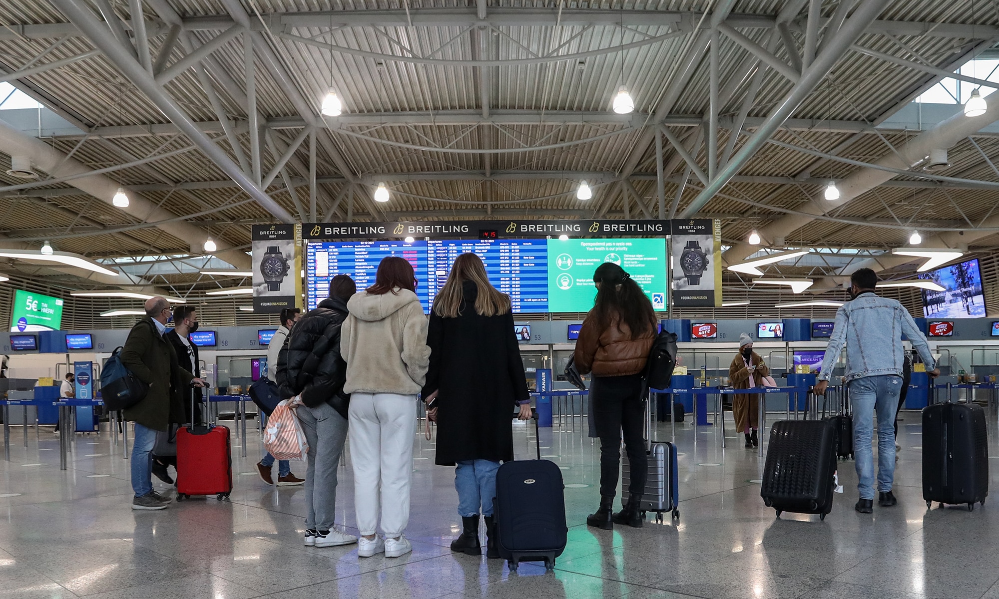 Πολίτες κοιτούν τις πτήσεις σε αεροδρόμιο