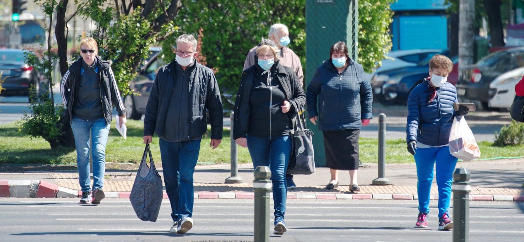 Άνθρωποι με προστατευτική μάσκα διασχίζουν τον δρόμο