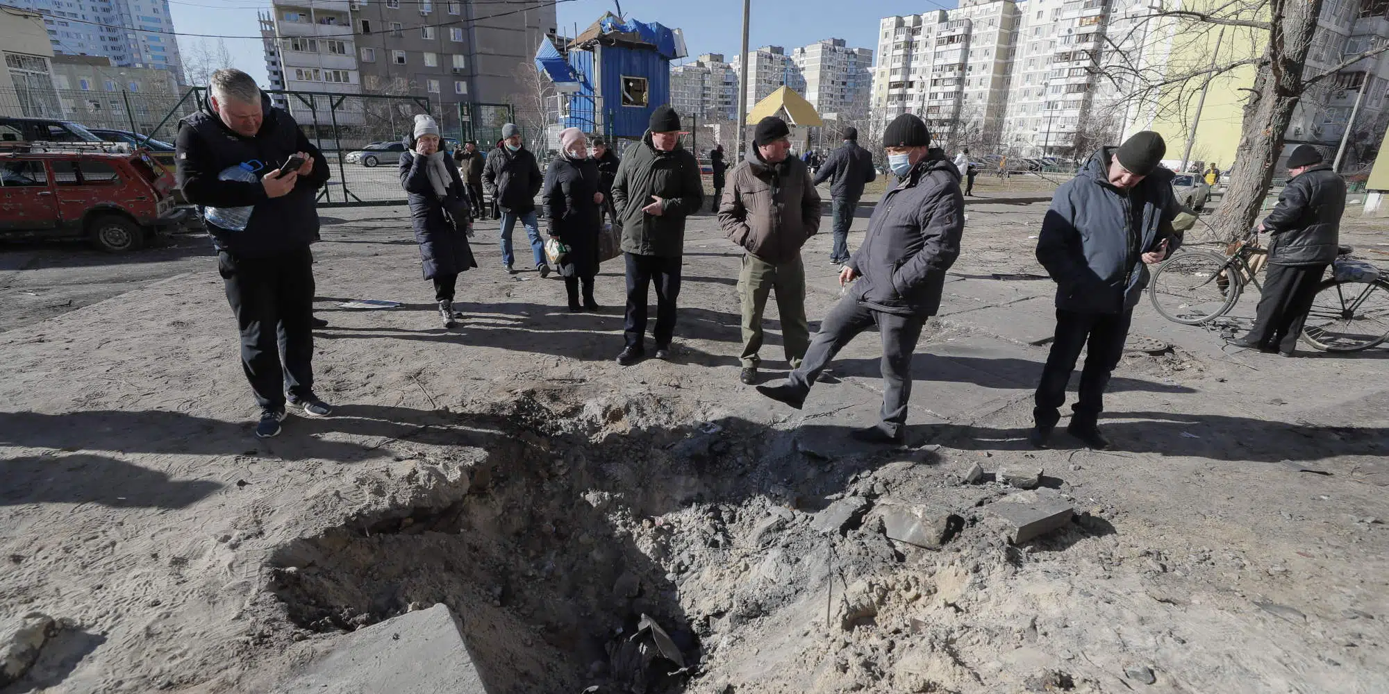 Πολίτες πάνω από σημάδι που άφησαν βομβαρδισμοί των ρωσικών δυνάμεων στο Χάρκοβο, στην Ουκρανία