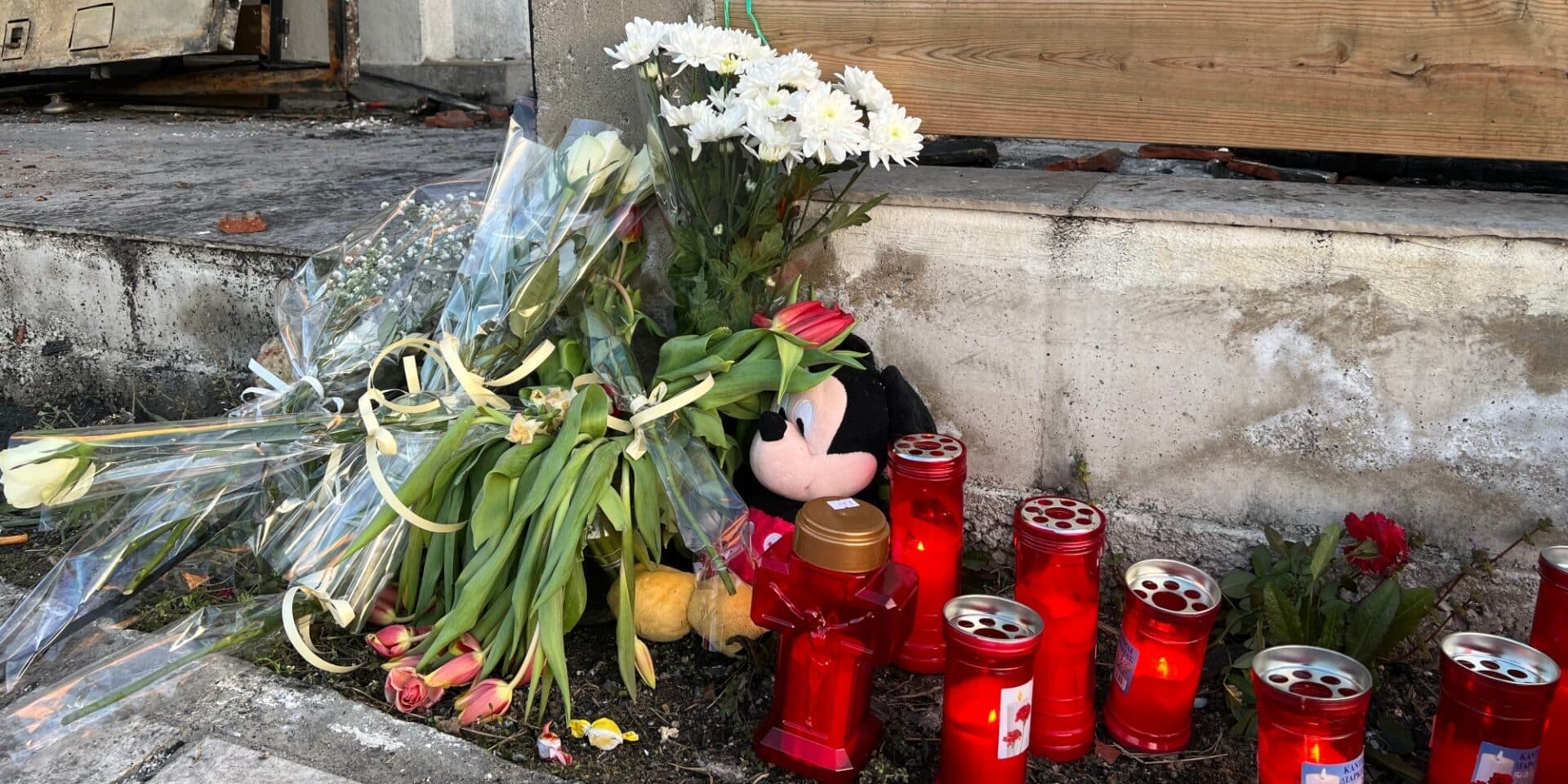 Λευκά λουλούδια, κουκλάκια και αναμμένα κεριά αφήνουν έξω από το σπίτι της 32χρονης που κάηκε μαζί με τα παιδιά της