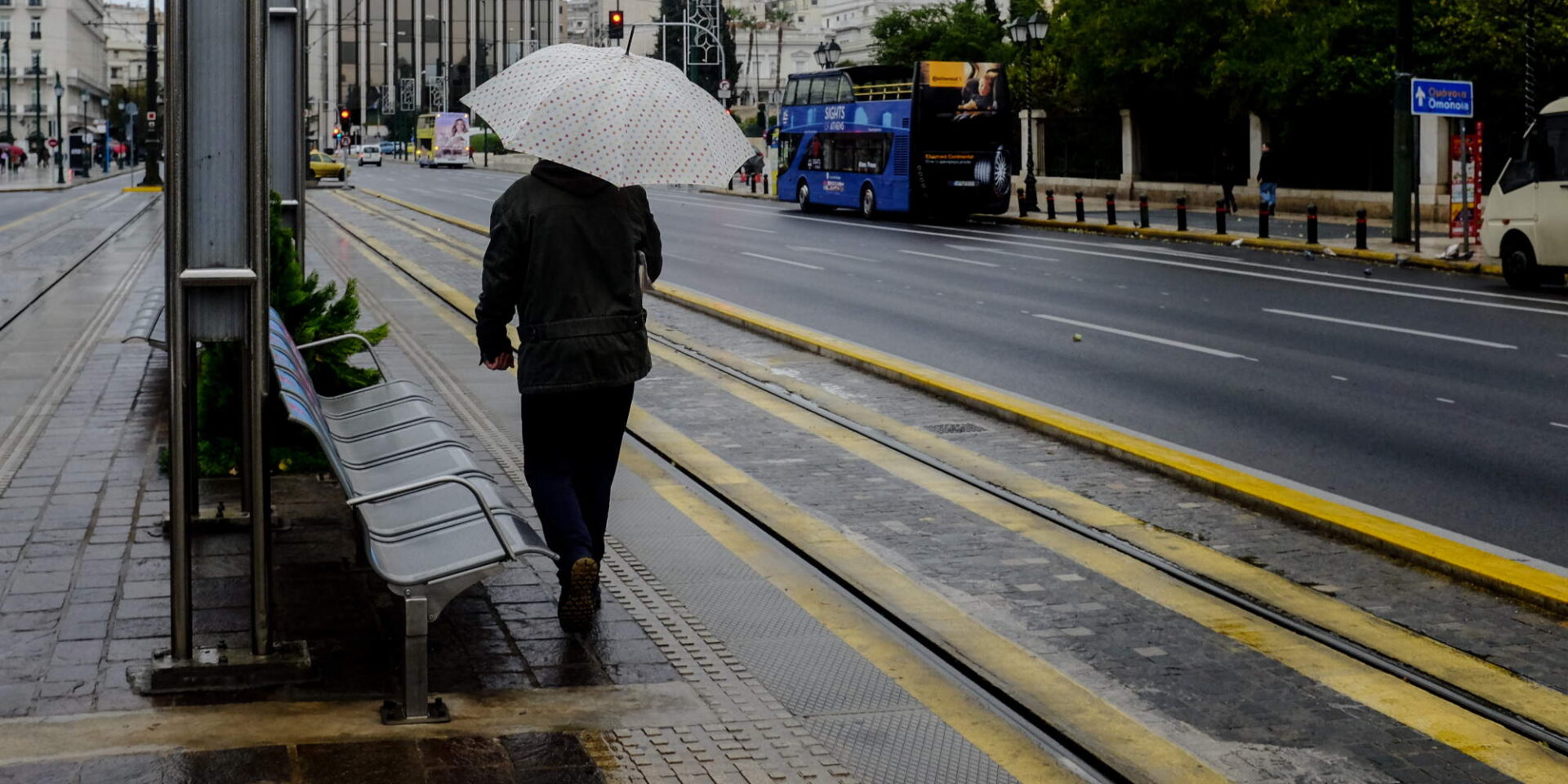 Άνδρας με ομπρέλα σε σταθμό του Τραμ