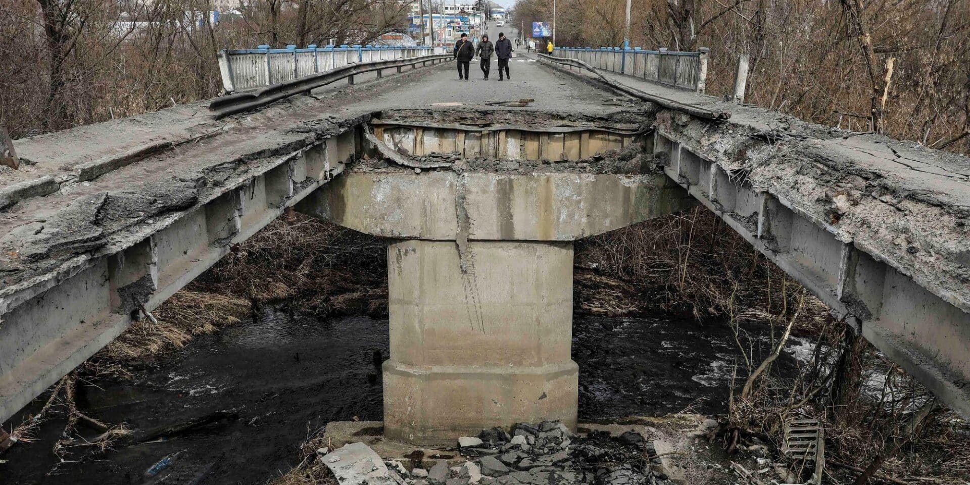 Πολίτες περπατούν μπροστά σε κατεστραμμένη γέφυρα στην Ουκρανία