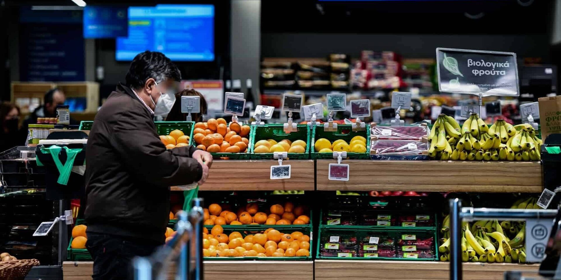 Πολίτης κοιτάζει τις τιμές σε μανάβικο σούπερ μάρκετ