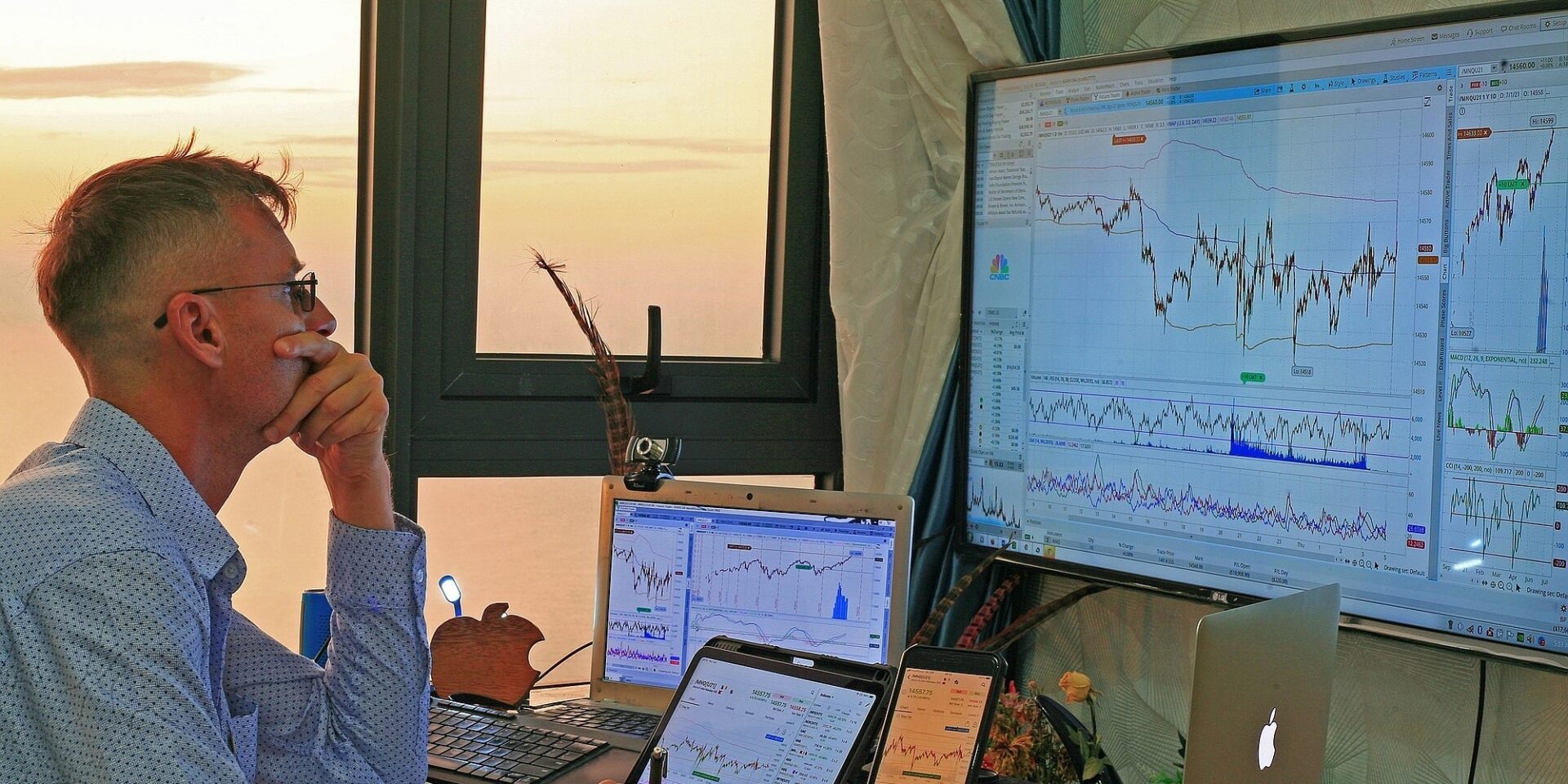 Επενδυτής μπροστά σε οικονομικούς δείκτες σε υπολογιστές