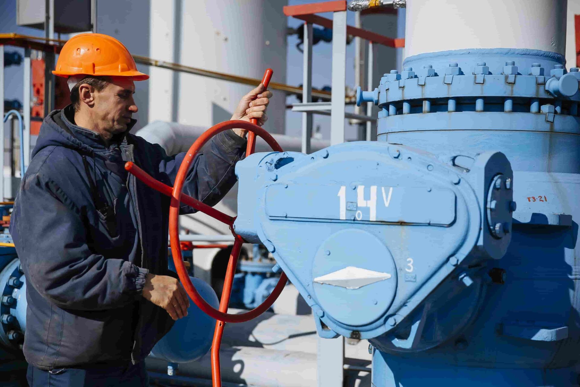Εργαζόμενος γυρίζει στρόφιγγα σε εγκαταστάσεις φυσικού αερίου