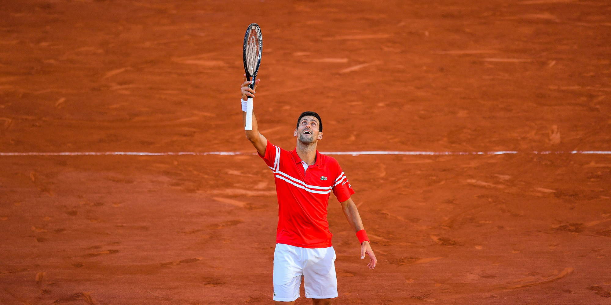Ο αθλητής του τένις, Νόβακ Τζόκοβιτς με τη ρακέτα ψηλά