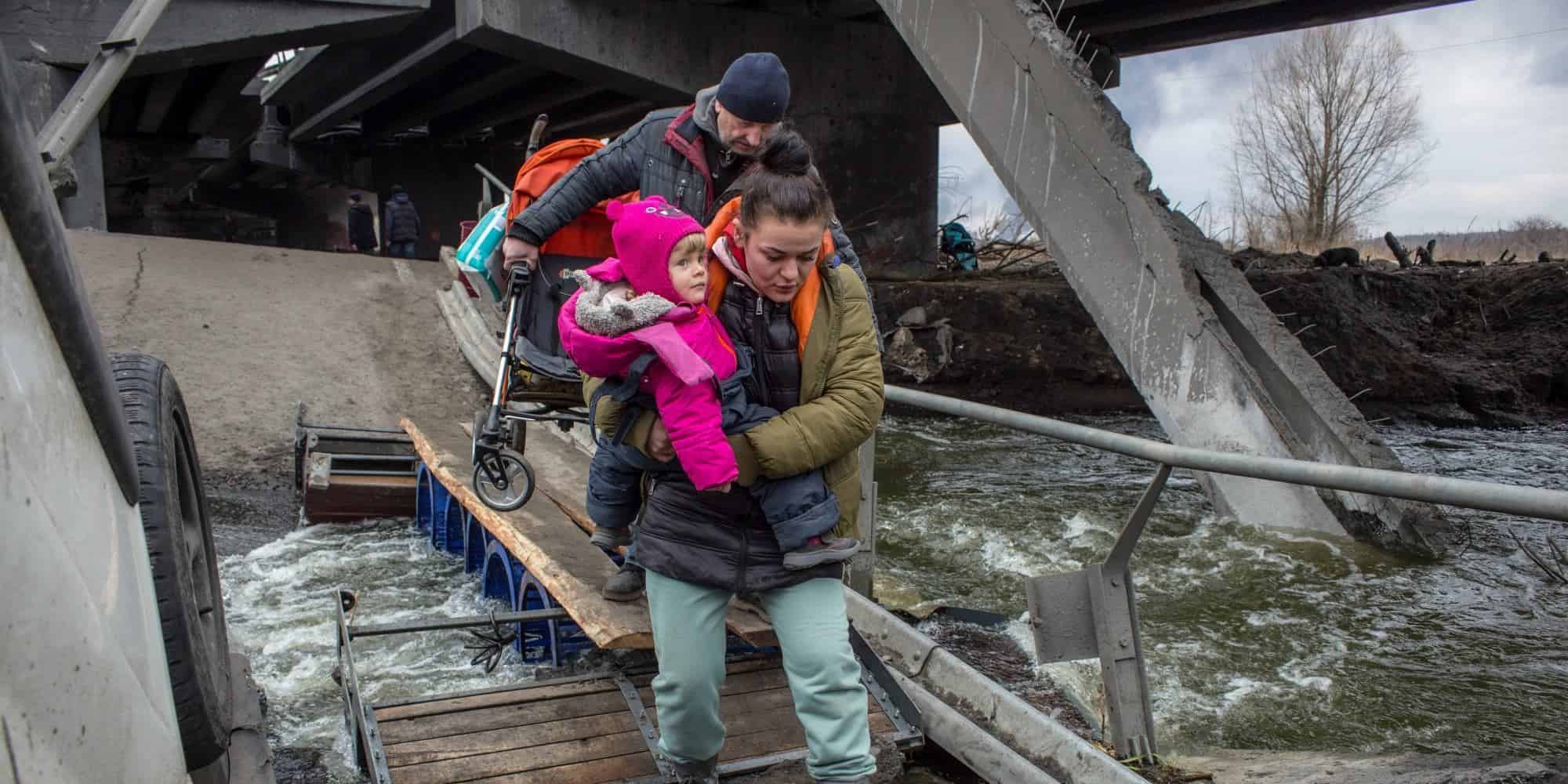 Μητέρα με μωρό στην αγκαλιά προσπαθεί να περάσει σε κατεστραμμένη γέφυρα