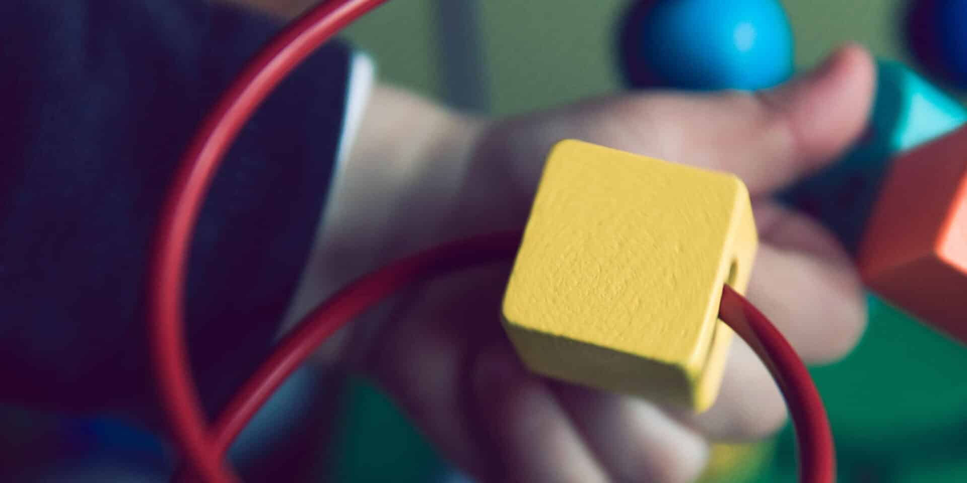 Παιδικό χέρι παίζει με παιχνίδι στο σπίτι