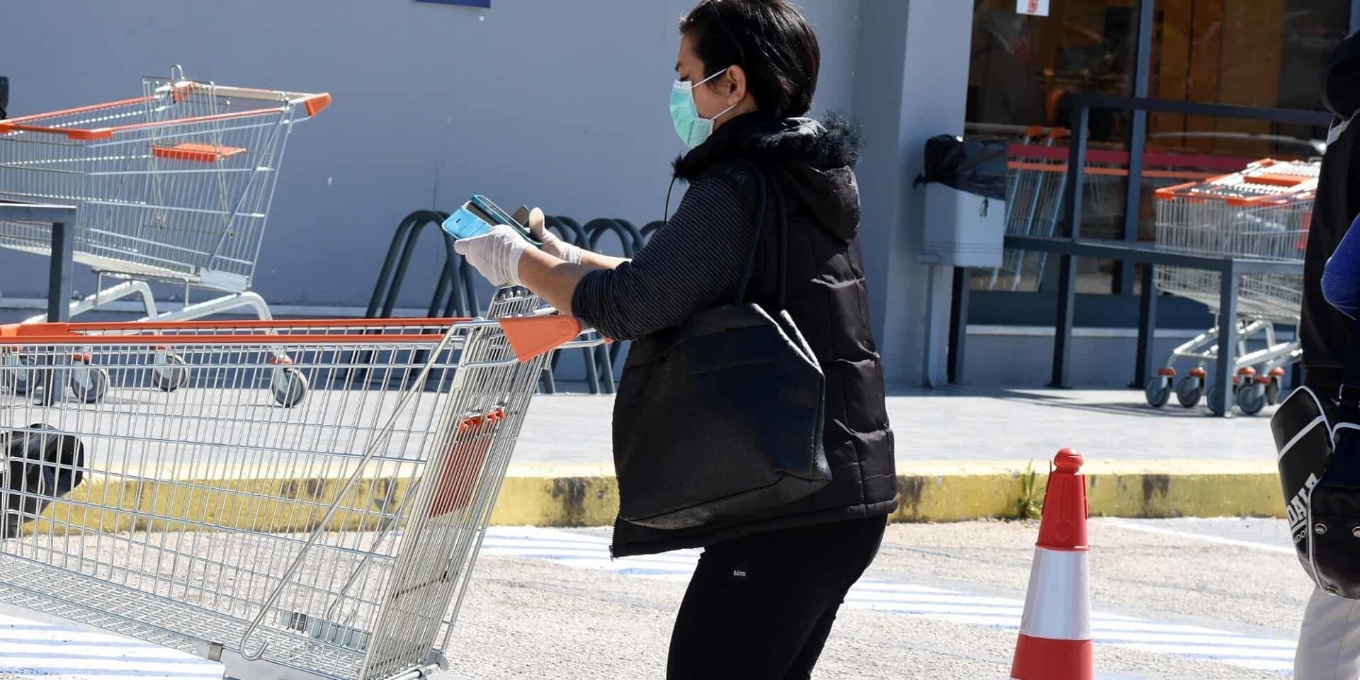 Κυρία με τη λίστα με τα ψώνια και καλάθι σούπερ μάρκετ