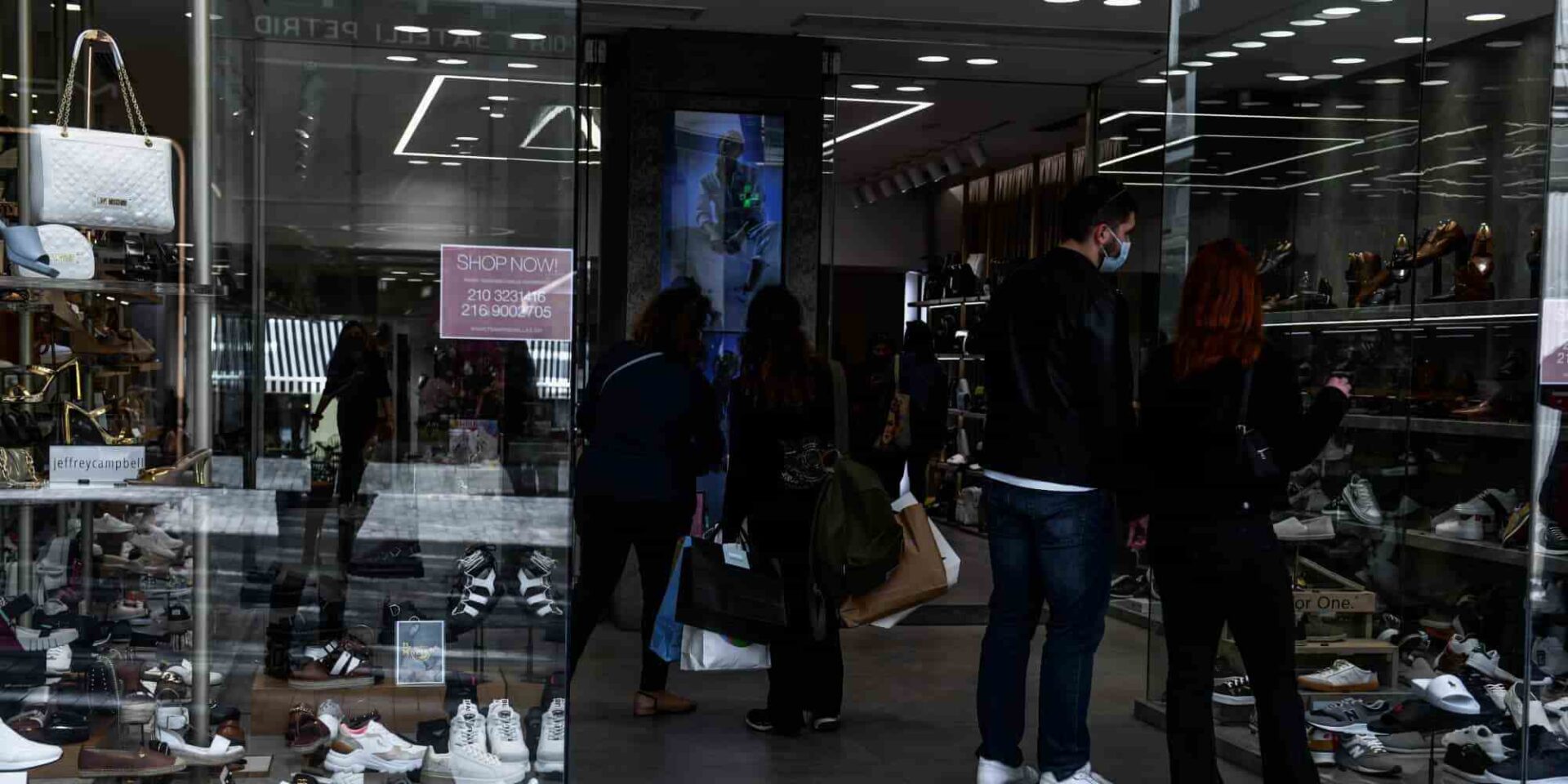 Πολίτες κοιτάζουν βιτρίνα καταστήματος στο κέντρο της Αθήνας