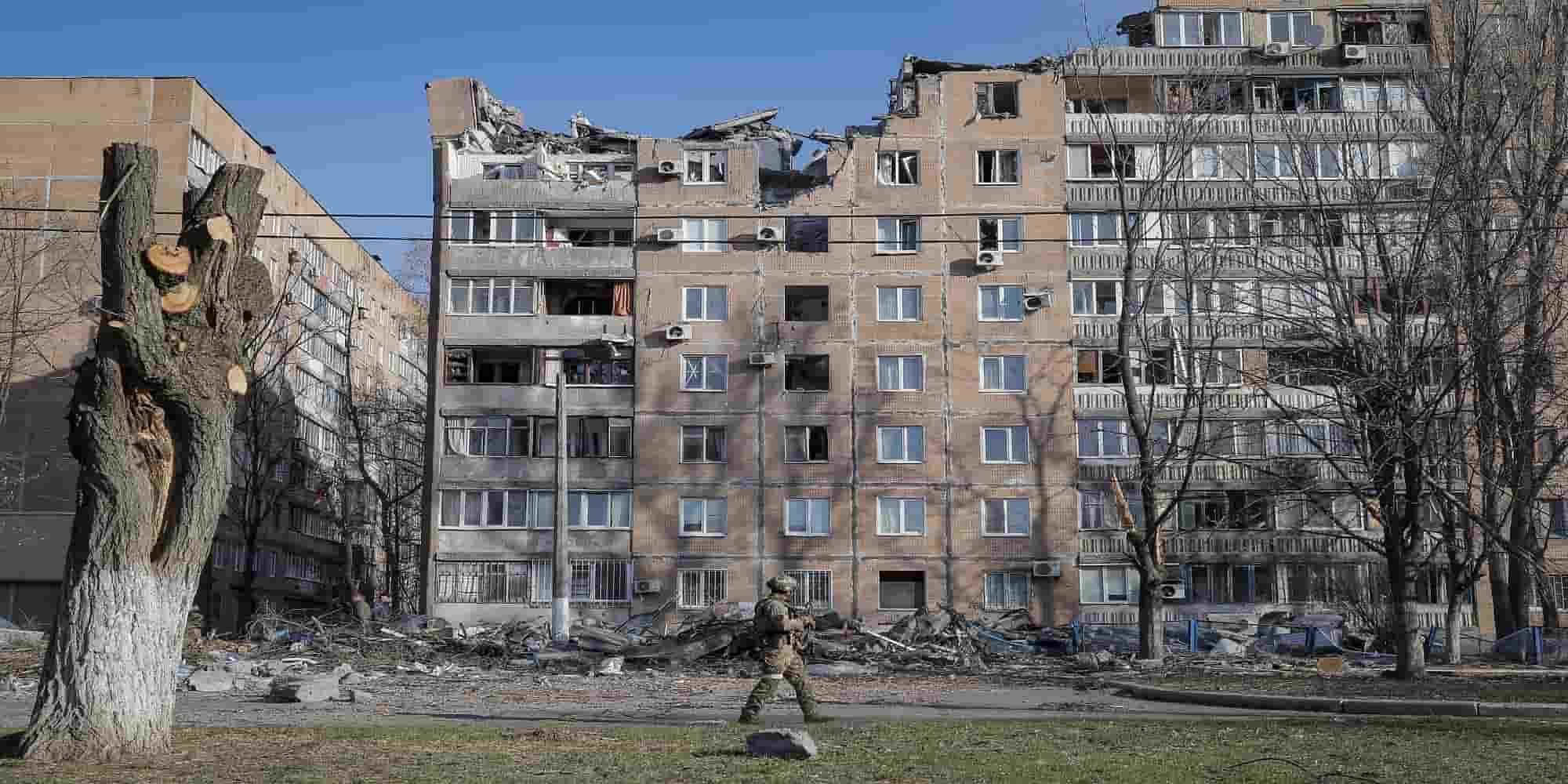 Ρώσος στρατιώτης περπατά μπροστά από κατεστραμμένες πολυκατοικίες που καταστράφηκαν κατά τον βομβαρδισμό στο Ντονέτσκ στην Ουκρανία
