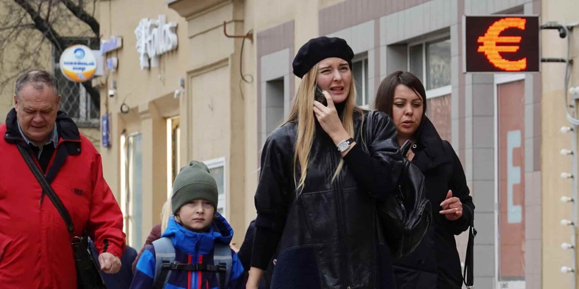 Άνθρωποι περπατούν μπροστά από ανταλλακτήριο συναλλάγματος στην Μόσχα