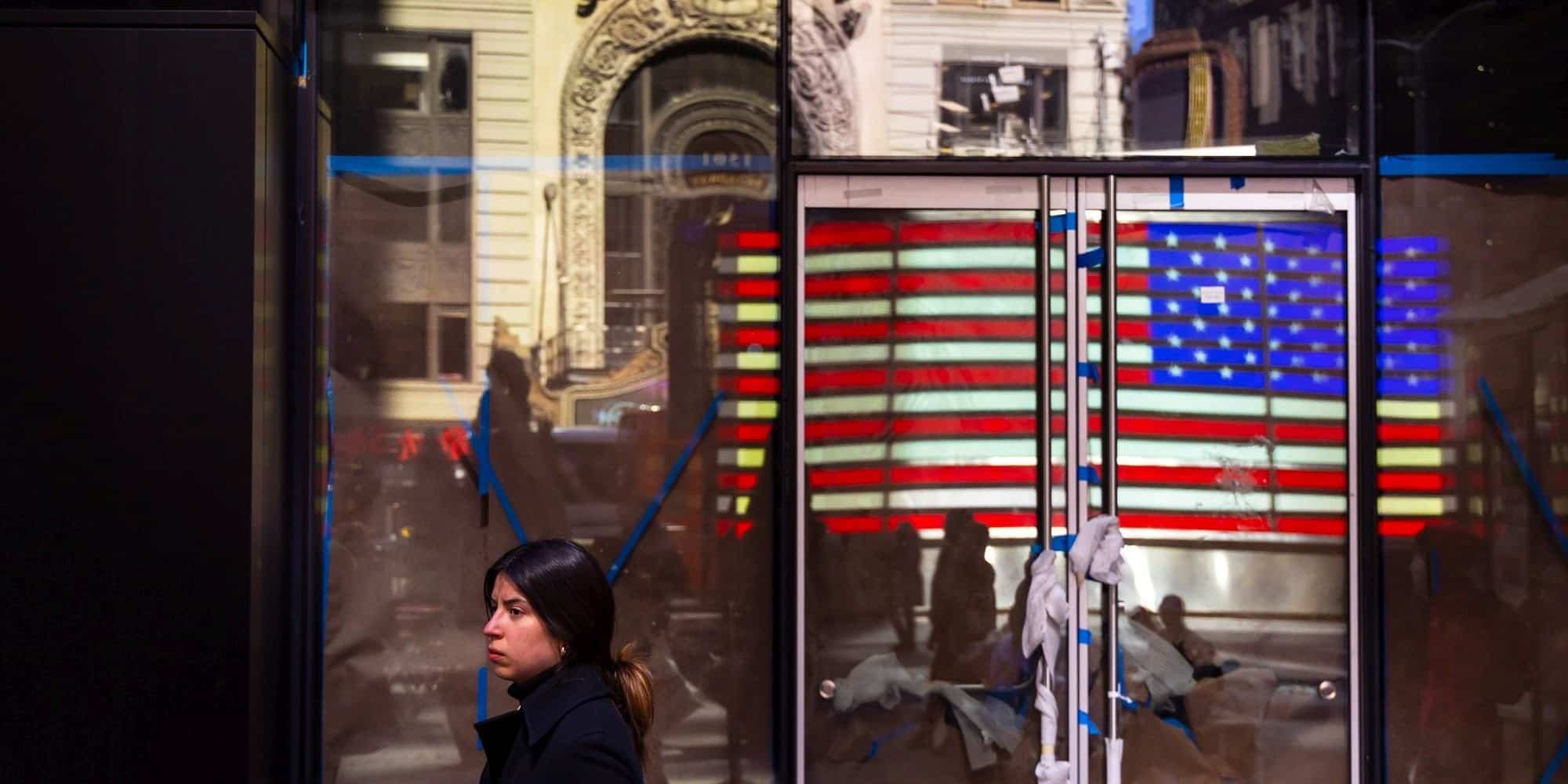 Μία κοπέλα περπατά μπροστά από ένα κλειστό κατάστημα στην Times Square στη Νέα Υόρκη