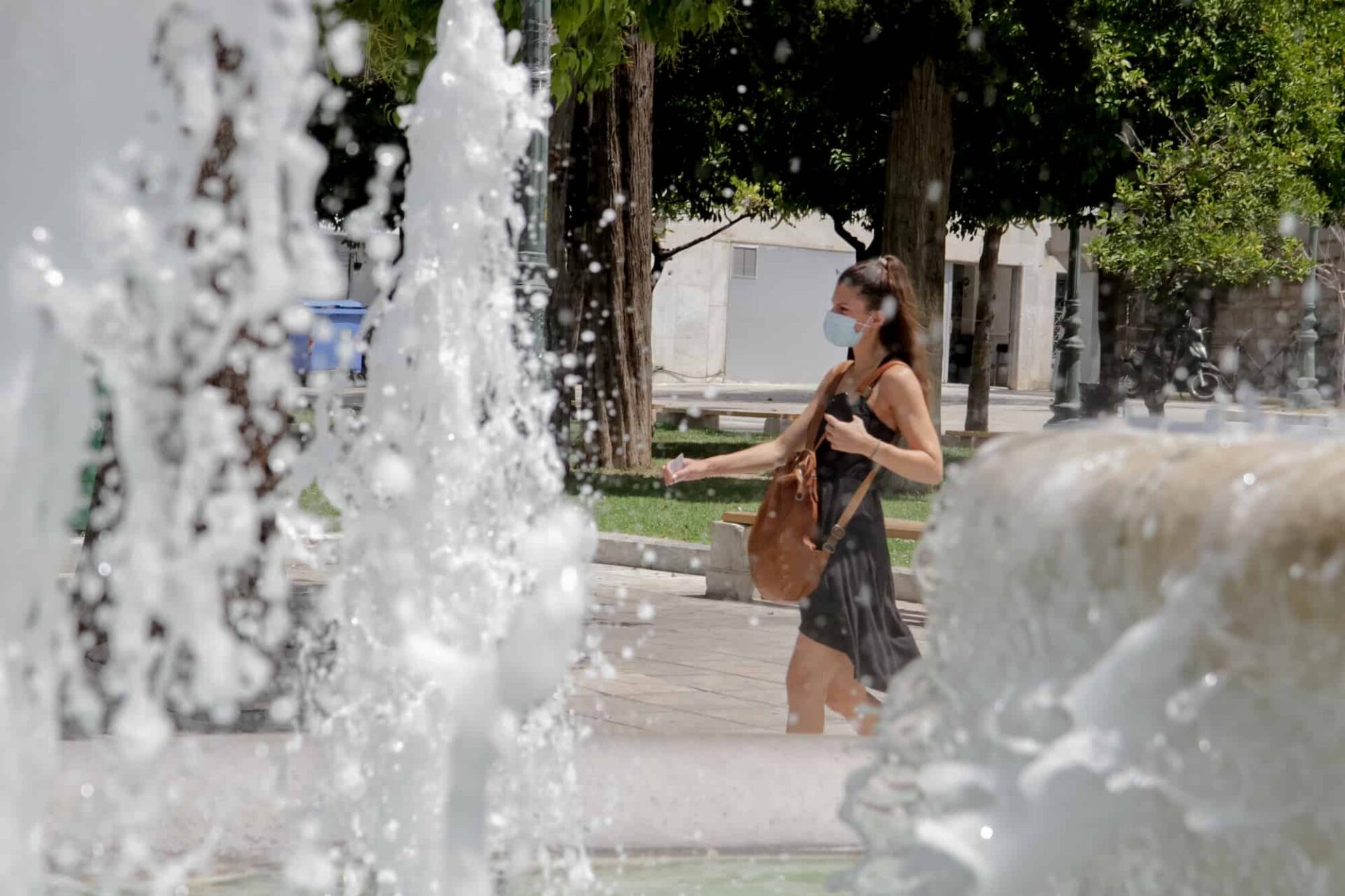 Γυναίκα περπατάει μέσα στον καύσωνα