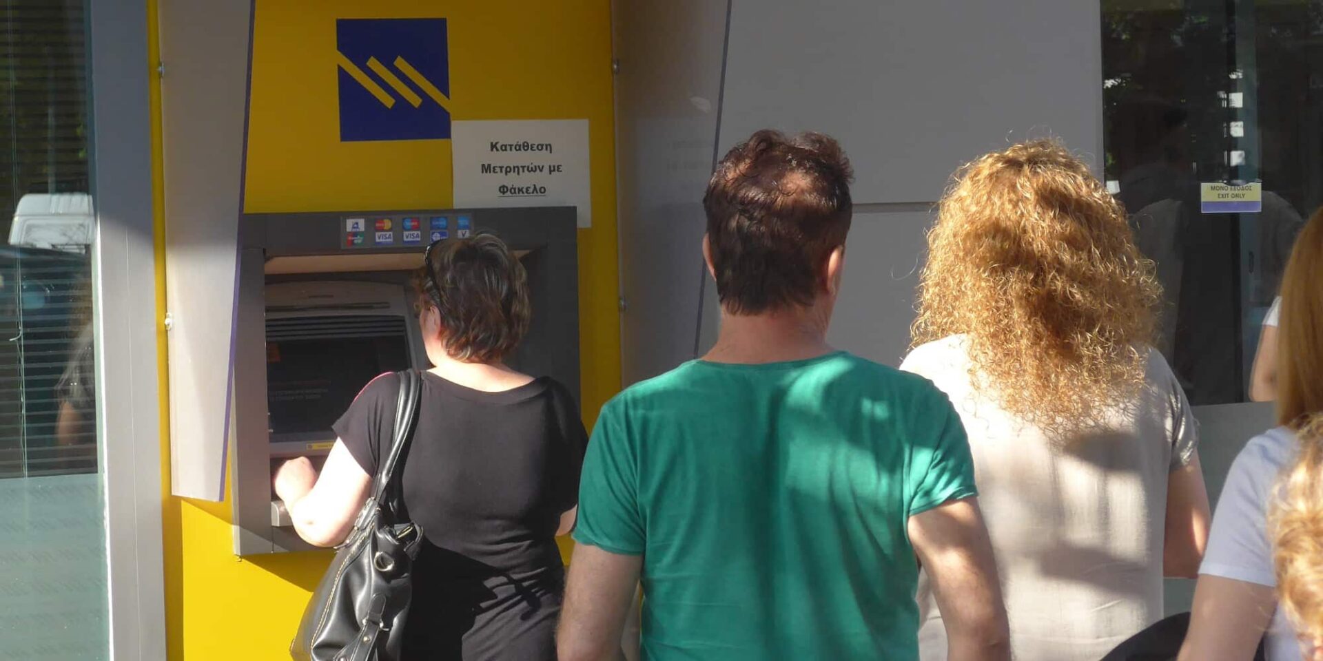 Κόσμος σε ΑΤΜ σε τράπεζα για πληρωμές