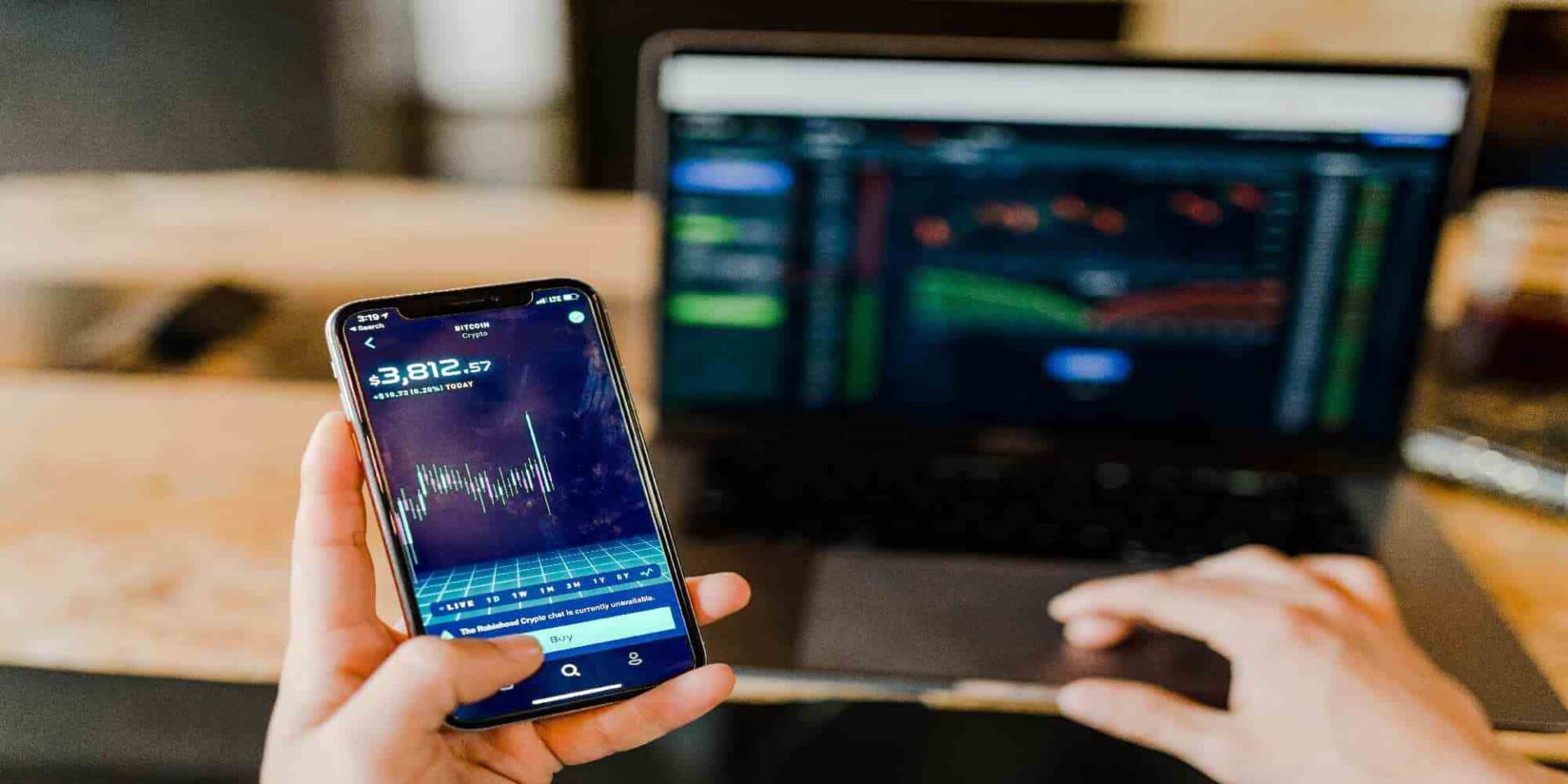 Πολίτης παρακολουθεί τις αποδόσεις σε smartphone και laptop