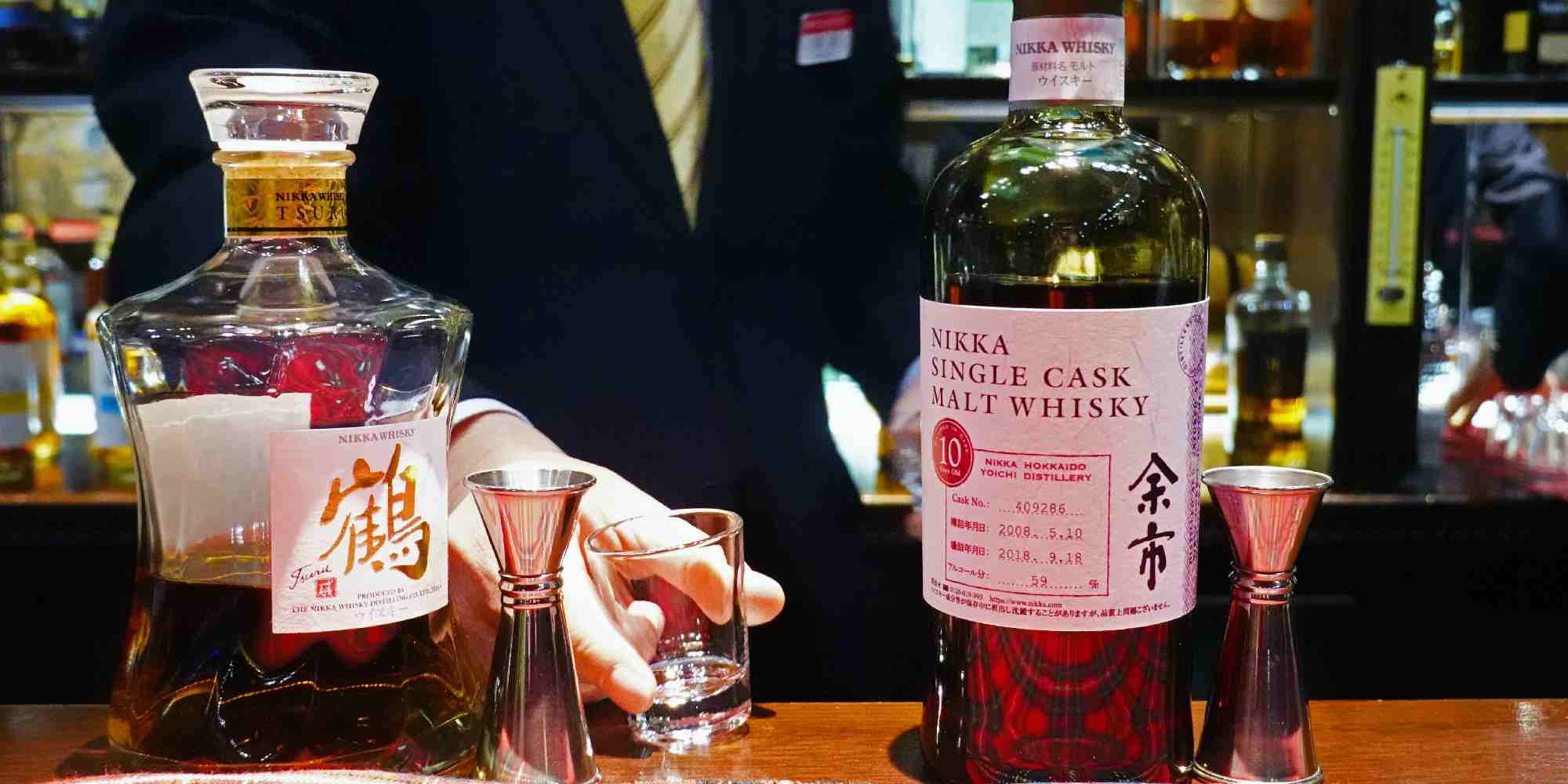 Κύριος με γραβάτα πίνει ποτό σε μπαρ στην Ιαπωνία