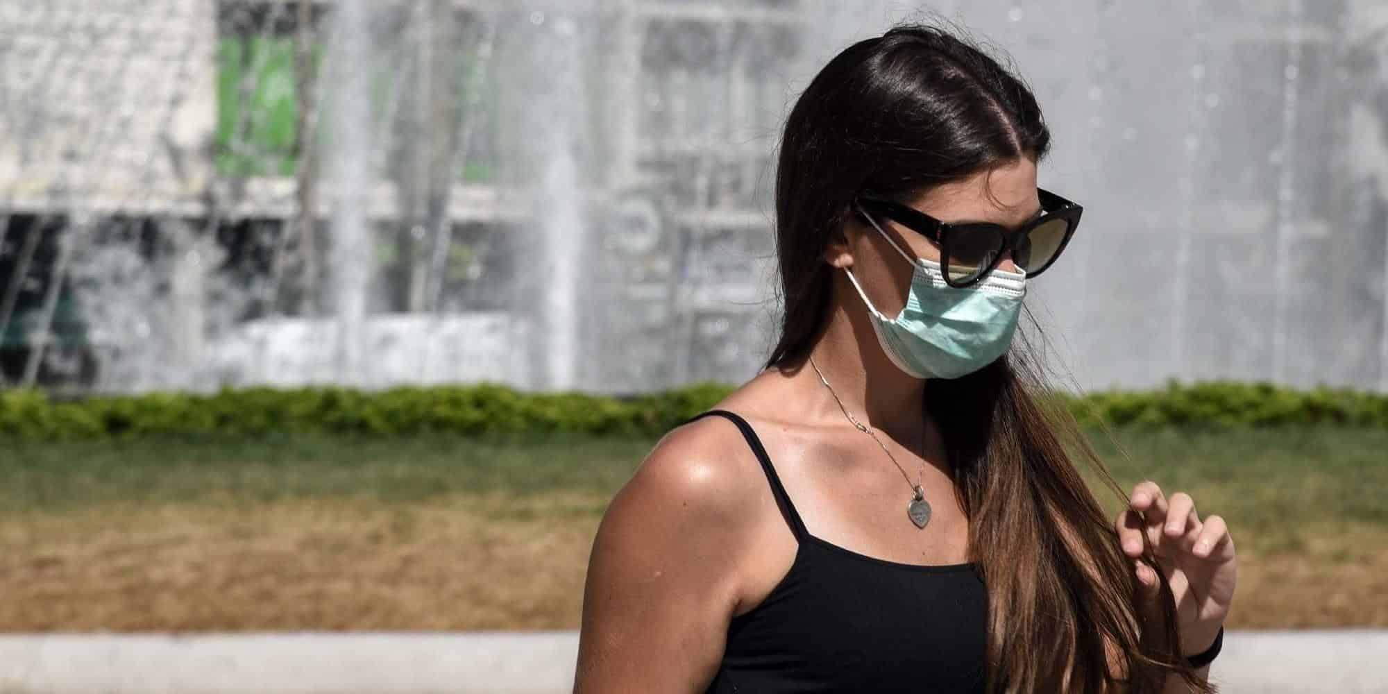 Κοπέλα περπατάει στο κέντρο της Αθήνας με μάσκα