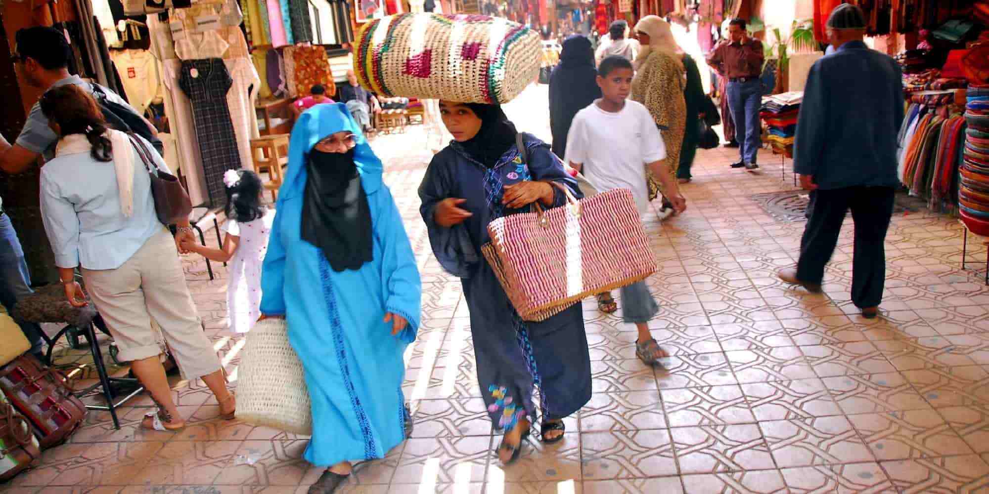 Κόσμος στην αγορά του Μαρόκου, γυναίκες κουβαλούν πράγματα στο κεφάλι