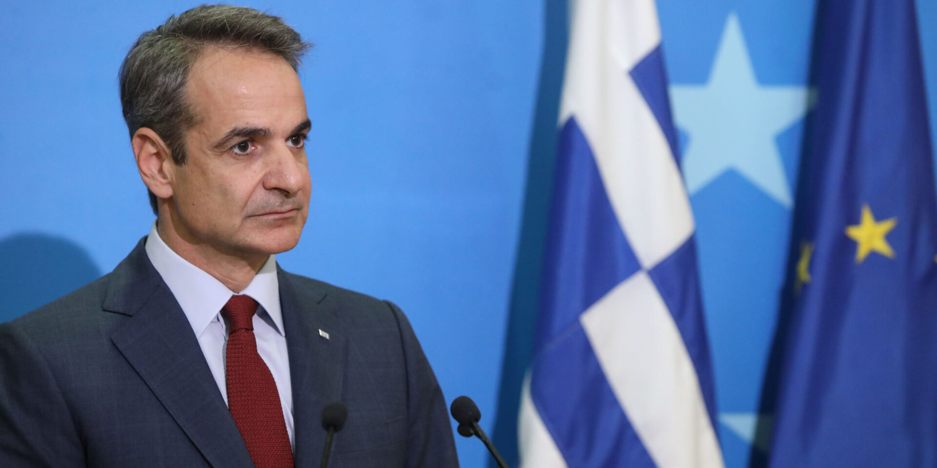 Ο Μητσοτάκης δίπλα στην ελληνική και την ευρωπαϊκή σημαία