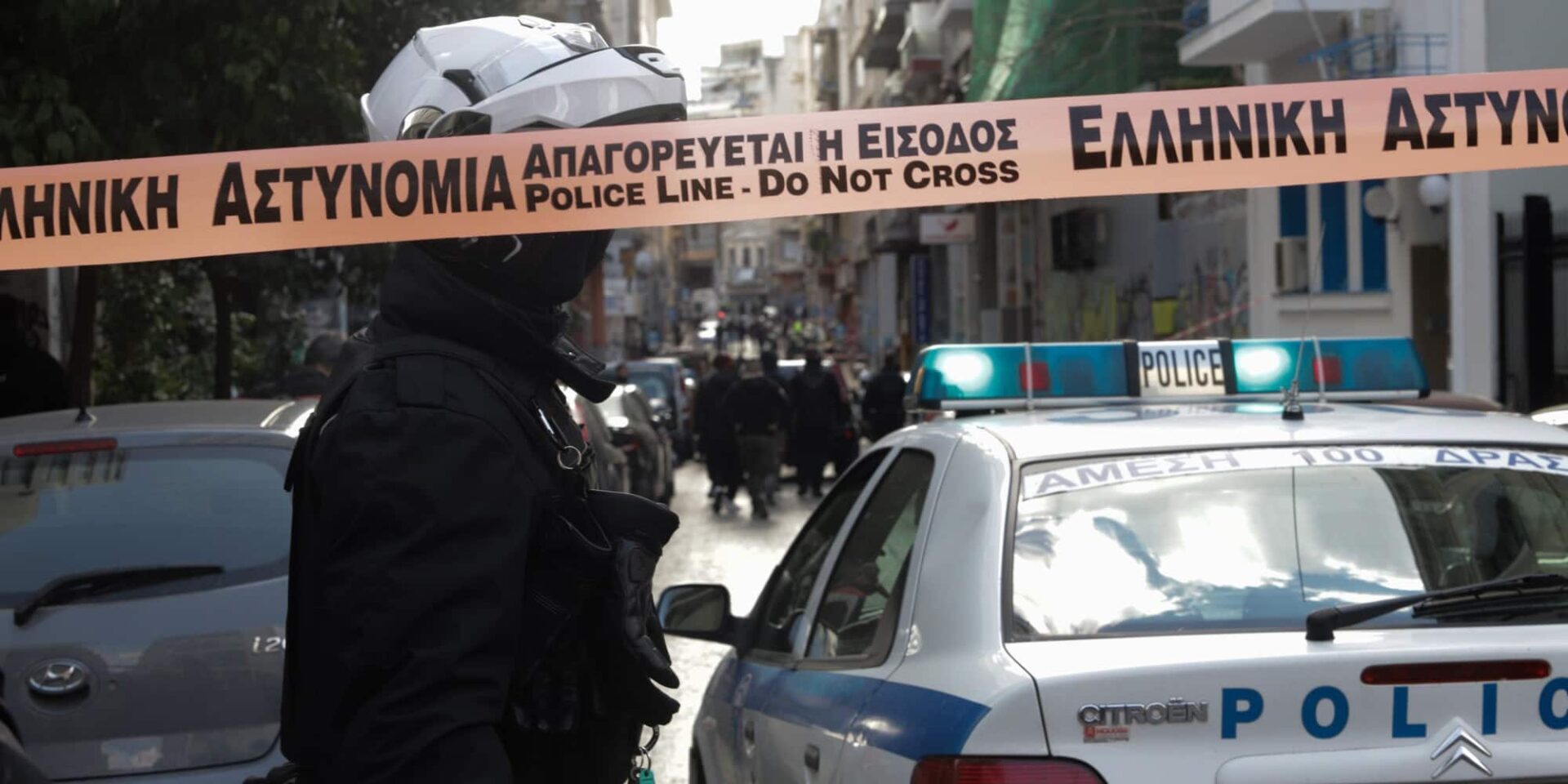 Αστυνομικός μπροστά από περιπολικό