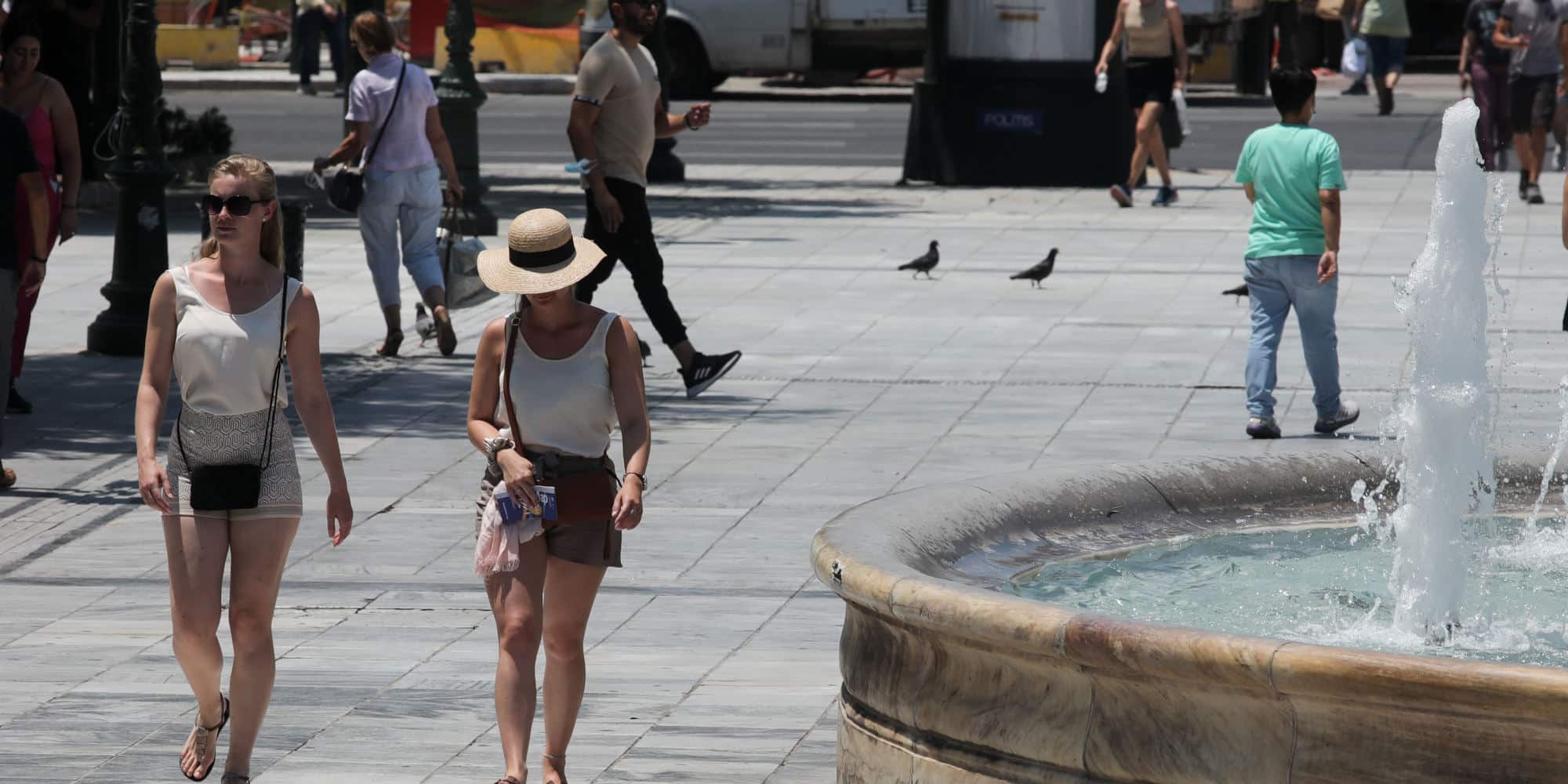 Κόσμος περπατά στη ζέστη στην πλατεία Συντάγματος