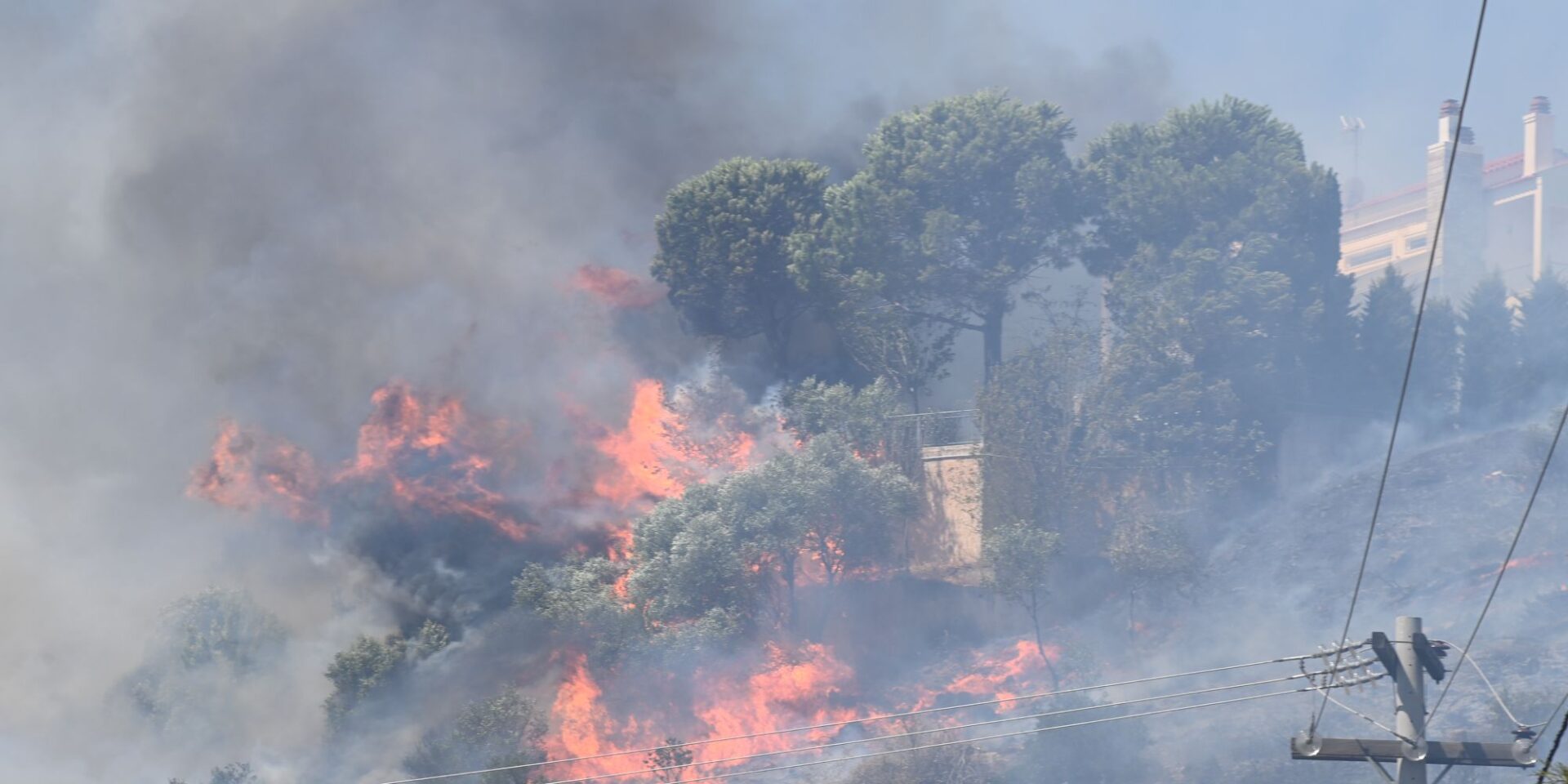 Οι φλόγες κοντά σε σπίτι