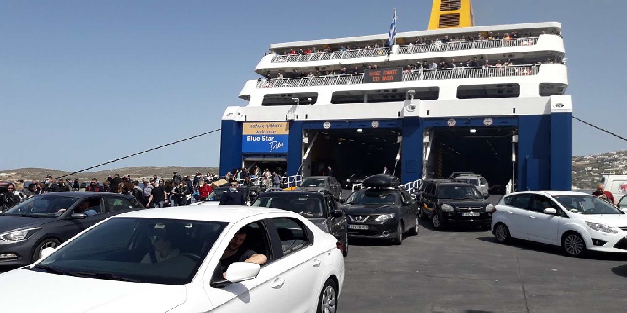 Κόσμος βγαίνει από το καράβι στο λιμάνι της Πάρου