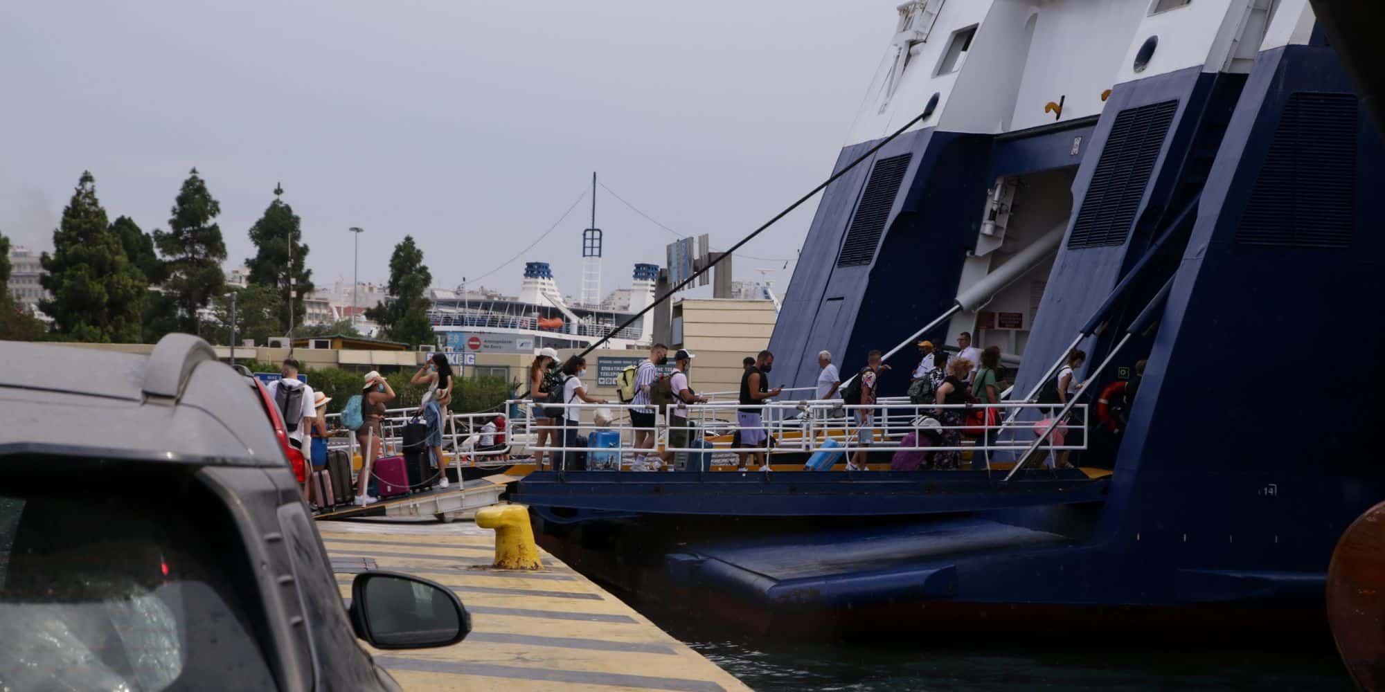 Ταξιδιώτες επιβιβάζονται σε πλοία στο λιμάνι του Πειραιά