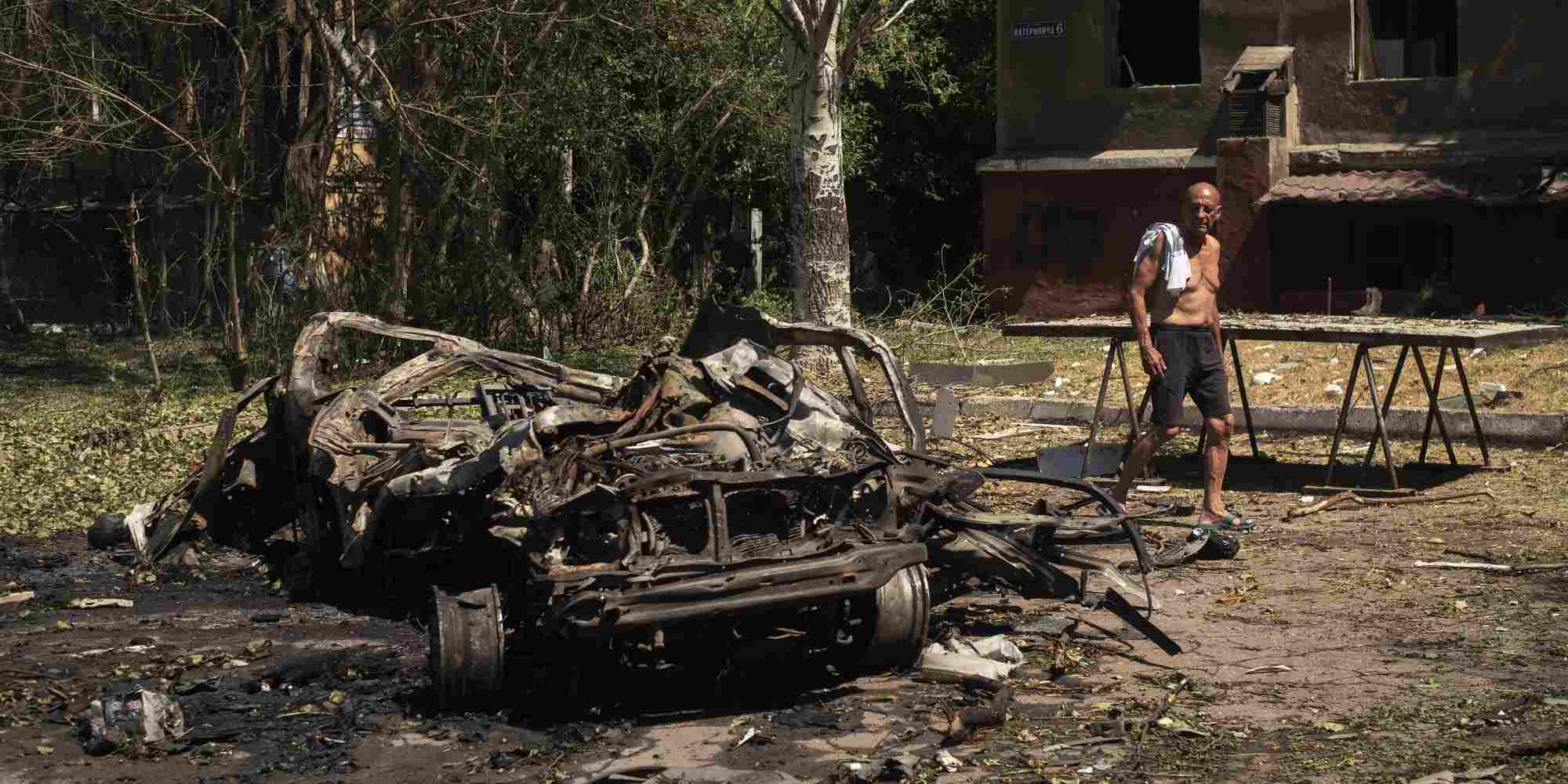 Ένας άνδρας περπατά μπροστά από ένα κατεστραμμένο αυτοκίνητο μετά από ρωσικό βομβαρδισμό στην περιοχή Ντονέτσκ στην Ουκρανία