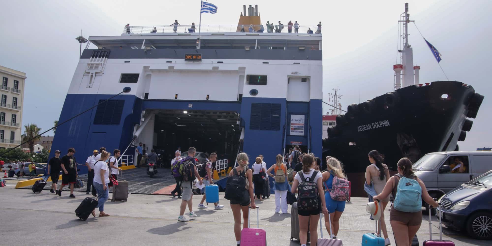 Ταξιδιώτες ετοιμάζονται να επιβιβαστούν σε πλοίο στο λιμάνι του Πειραιά