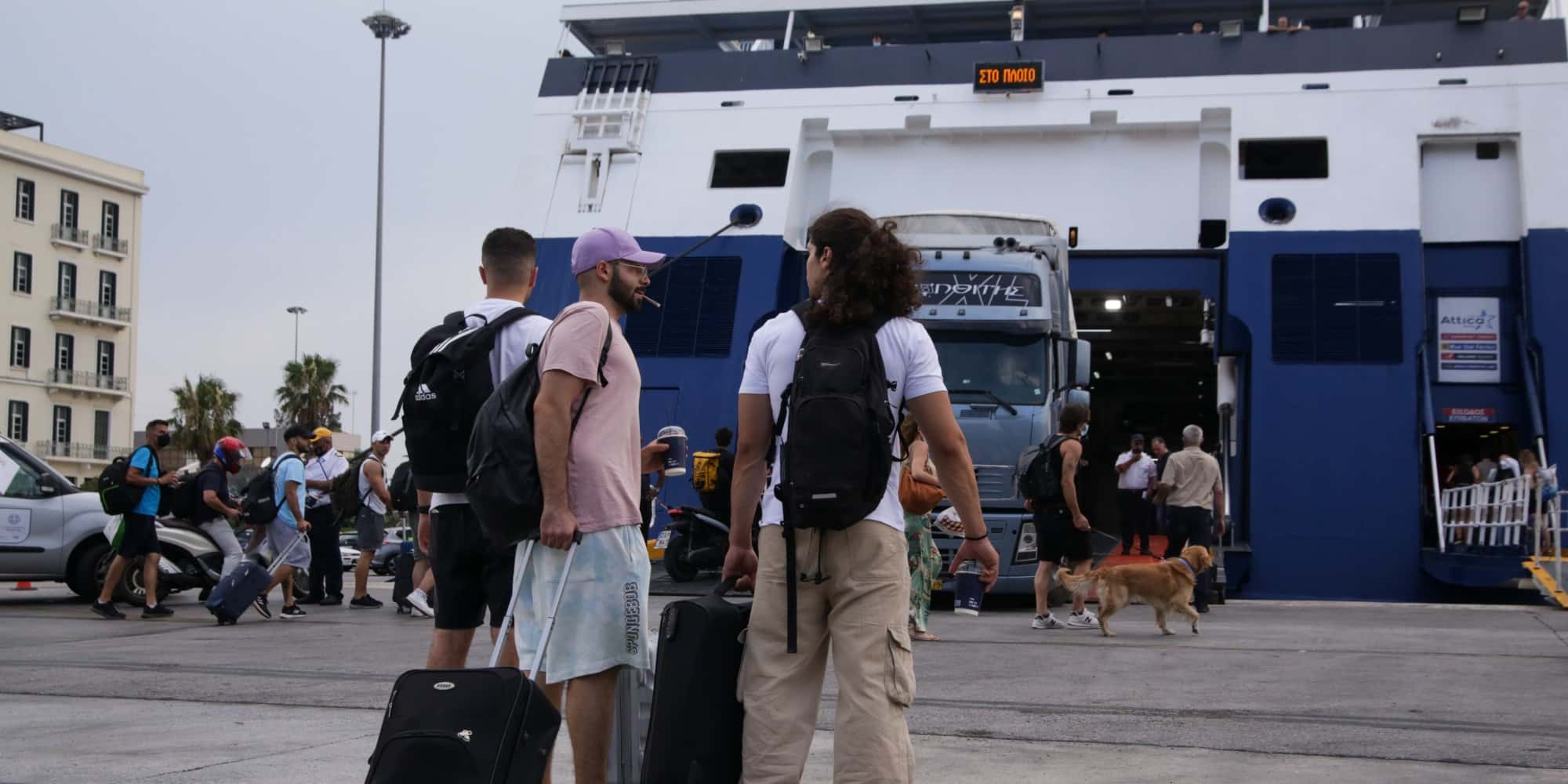 Ταξιδιώτες ετοιμάζονται να επιβιβαστούν σε πλοία στο λιμάνι του Πειραιά