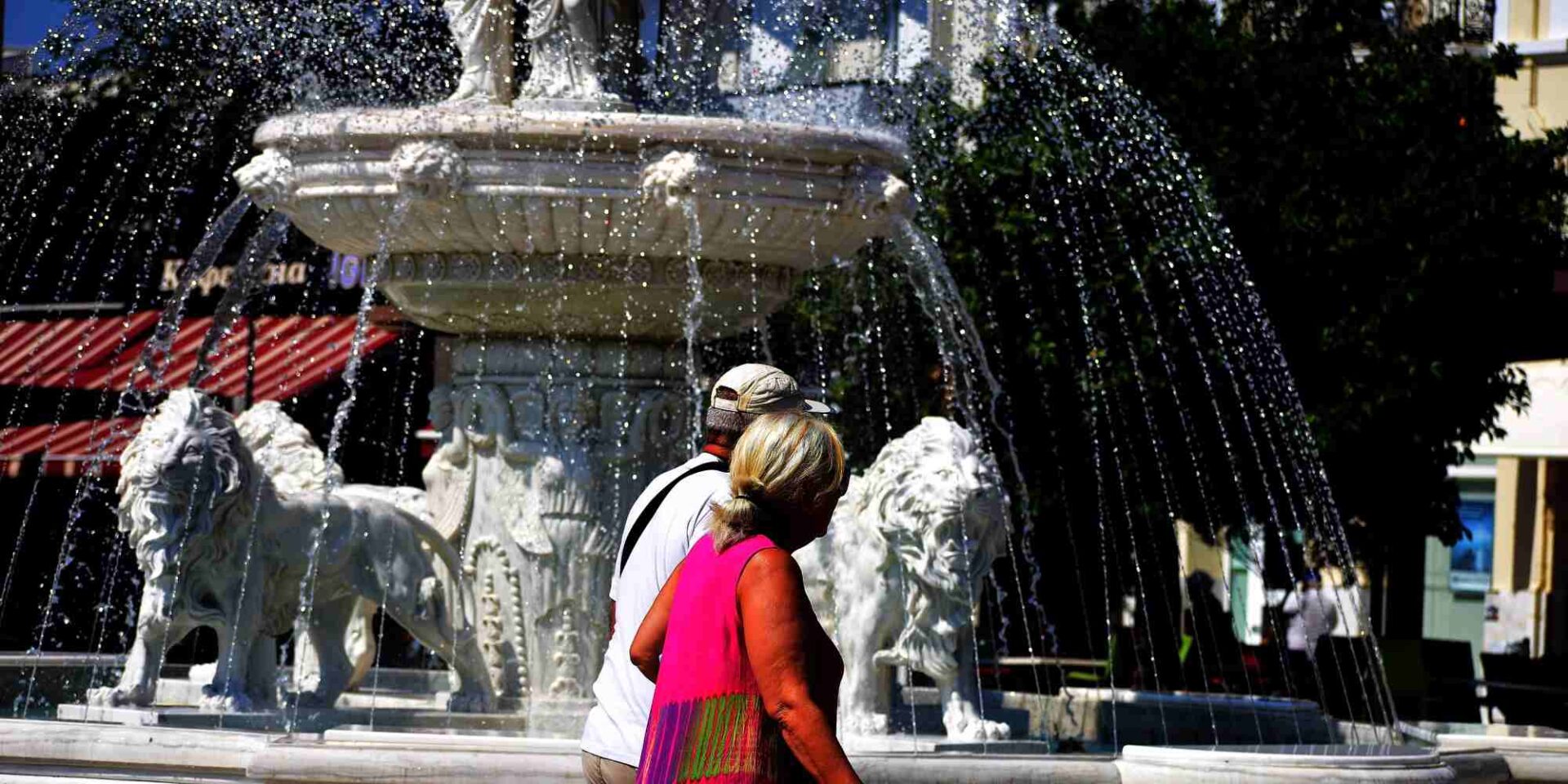 Ζευγάρι περνάει μπροστά από σιντριβάνι στο Άργος