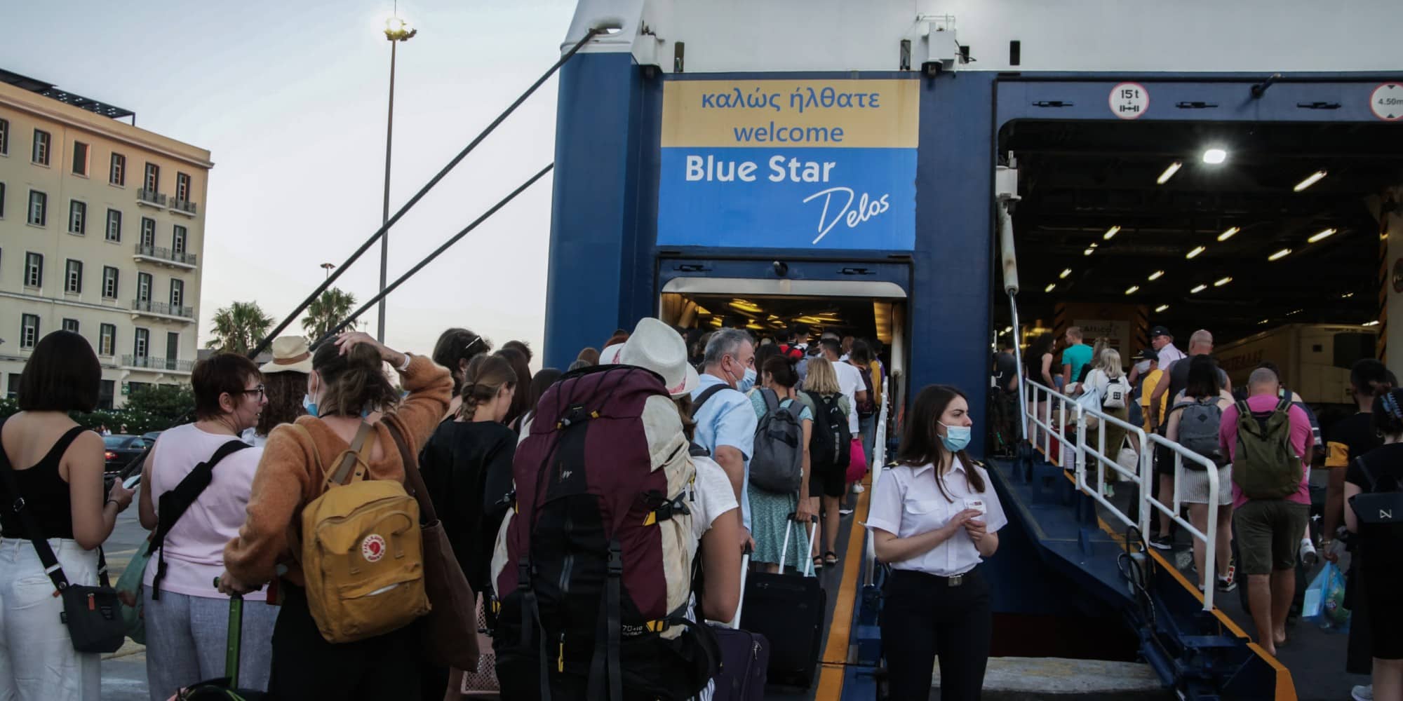 Ταξιδιώτες ετοιμάζονται να επιβιβαστούν σε πλοία στο λιμάνι του Πειραιά για τις καλοκαιρινές διακοπές