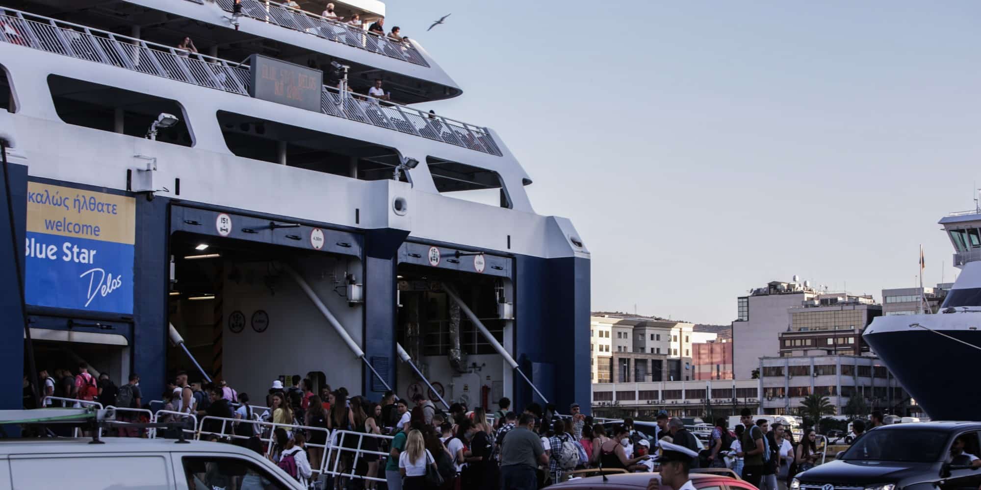 Ταξιδιώτες επιβιβάζονται σε πλοία στο λιμάνι του Πειραιά