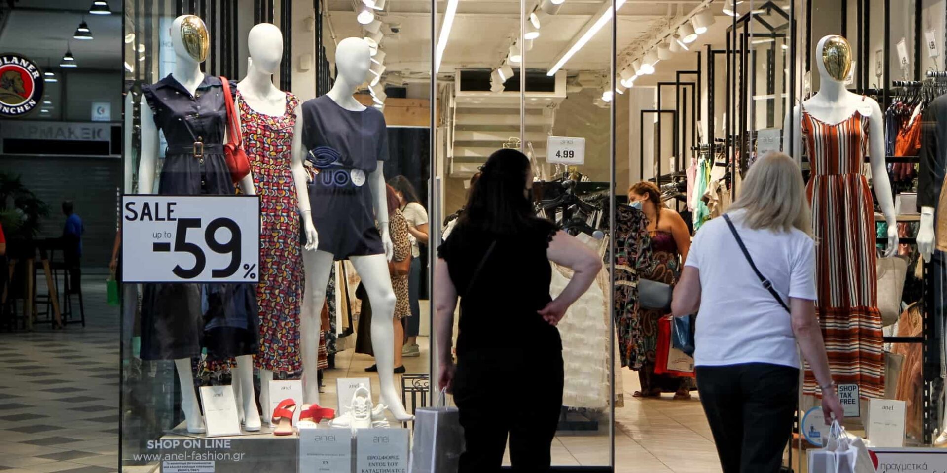 Γυναίκες κοιτούν κατάστημα στις θερινές εκπτώσεις