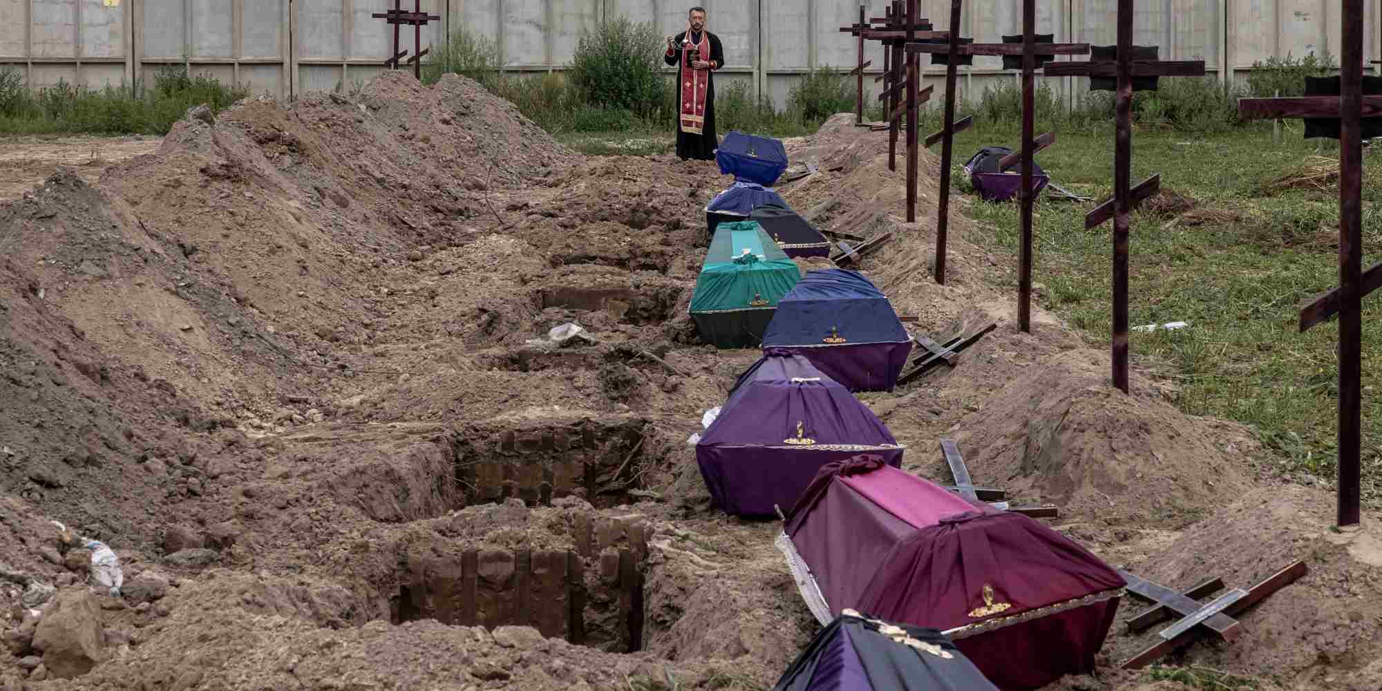 Ιερέας ευλογεί τα λείψανα αγνώστων που σκοτώθηκαν στην περιοχή Bucha, κατά τη διάρκεια της μαζικής ταφής σε ένα νεκροταφείο στην Bucha, βορειοδυτικά του Κιέβου