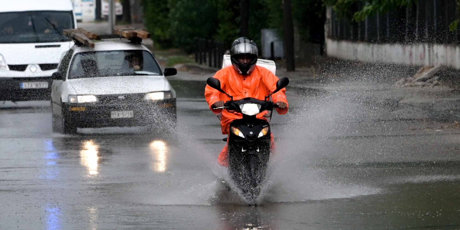 Οδηγός σε μηχανάκι την ώρα που έχει έντονη βροχόπτωση στην περιοχή της Δροσιάς