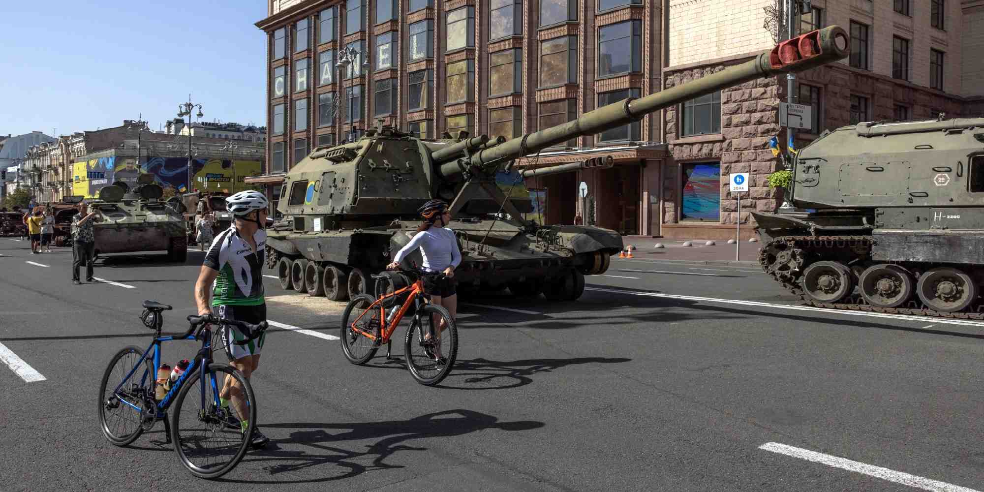 Ουκρανοί ποδηλάτες βλέπουν ρωσικά τεθωρακισμένα στρατιωτικά οχήματα που είχαν καταληφθεί σε μάχες από τον ουκρανικό στρατό στο κέντρο του Κιέβου