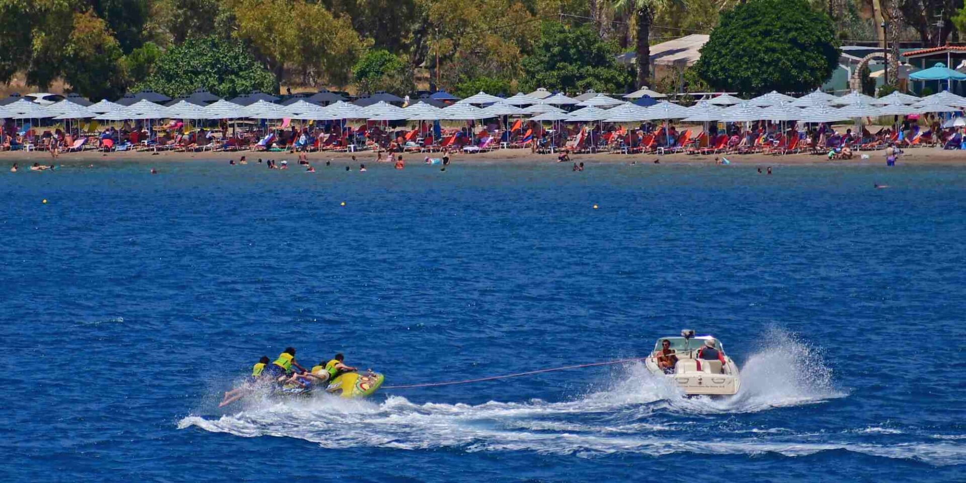 Λουόμενοι κάνουν θαλάσσια σπορ στην παραλία Καραθώνα στην πόλη του Ναυπλίου
