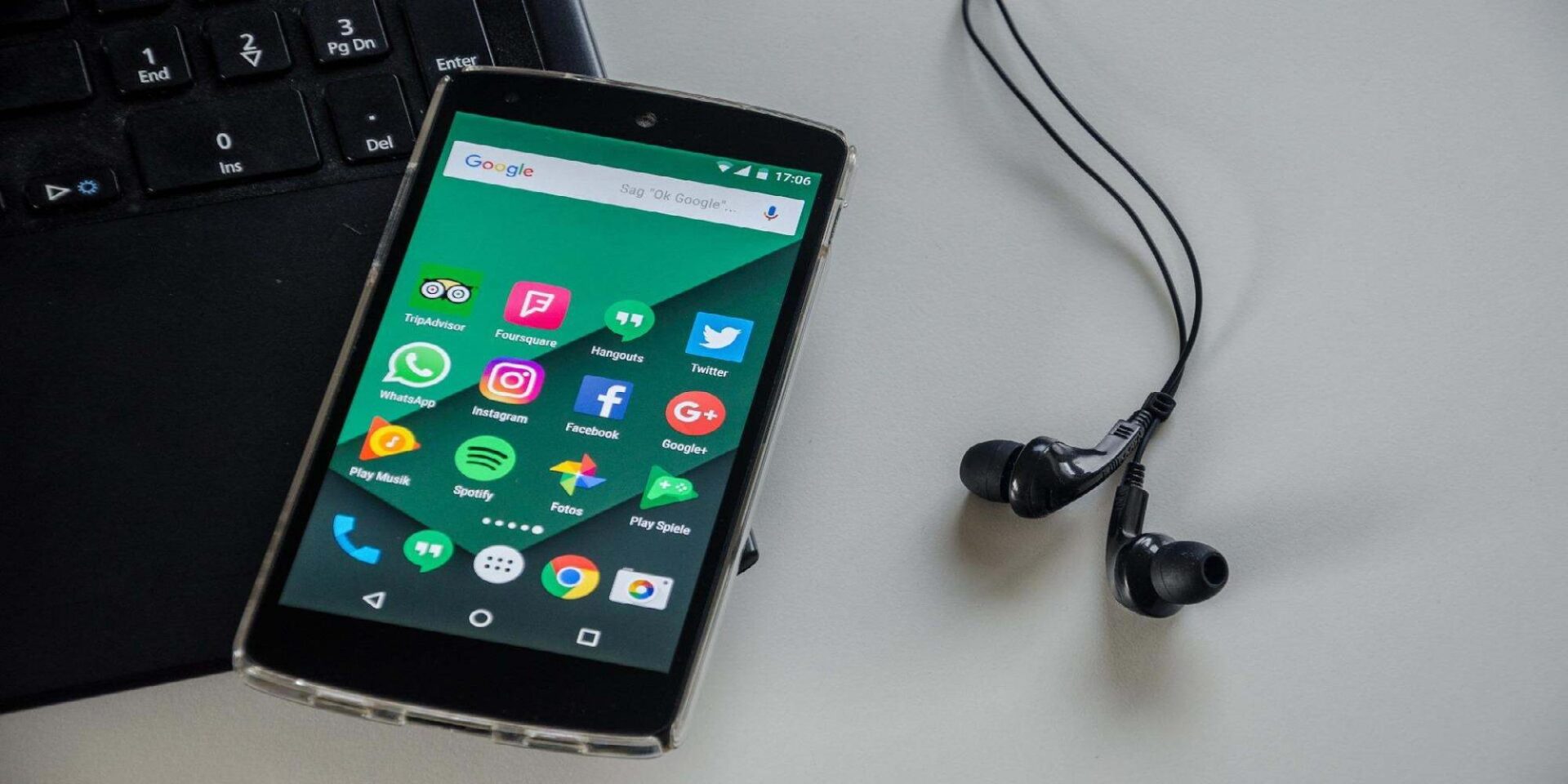 Smartphone με ακουστικά πάνω σε πληκτρολόγιο