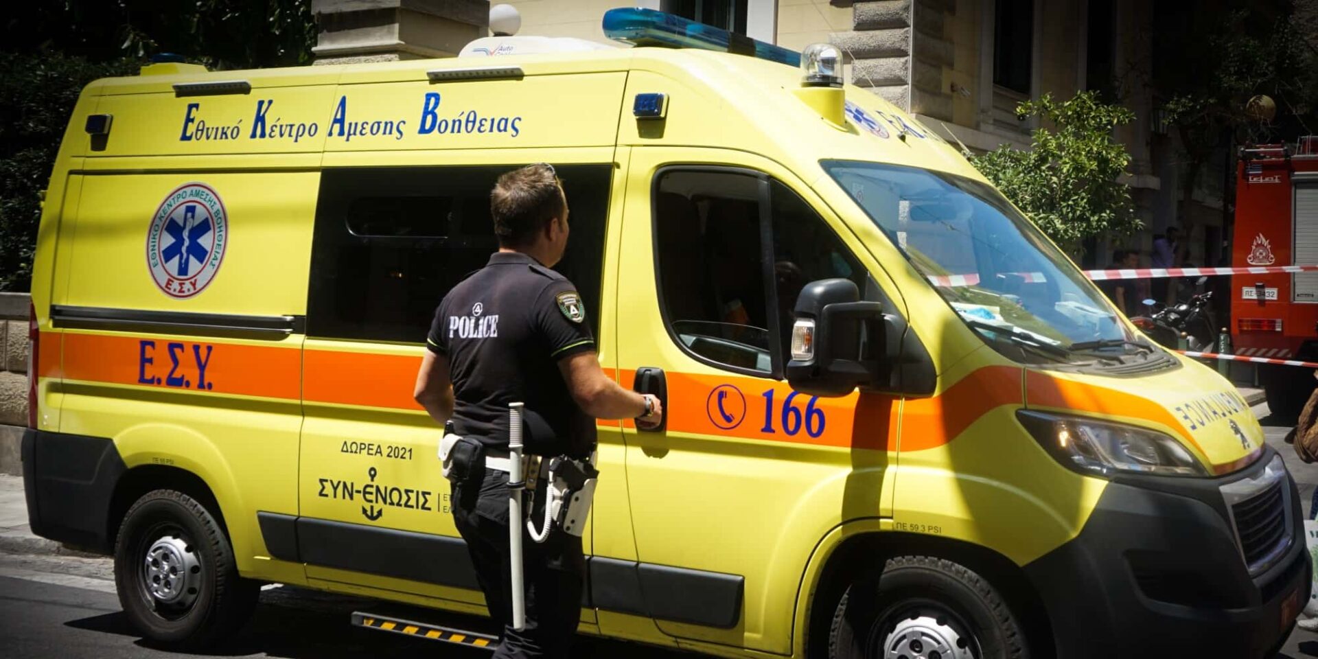 Αστυνομικός μπροστά από ασθενοφόρο