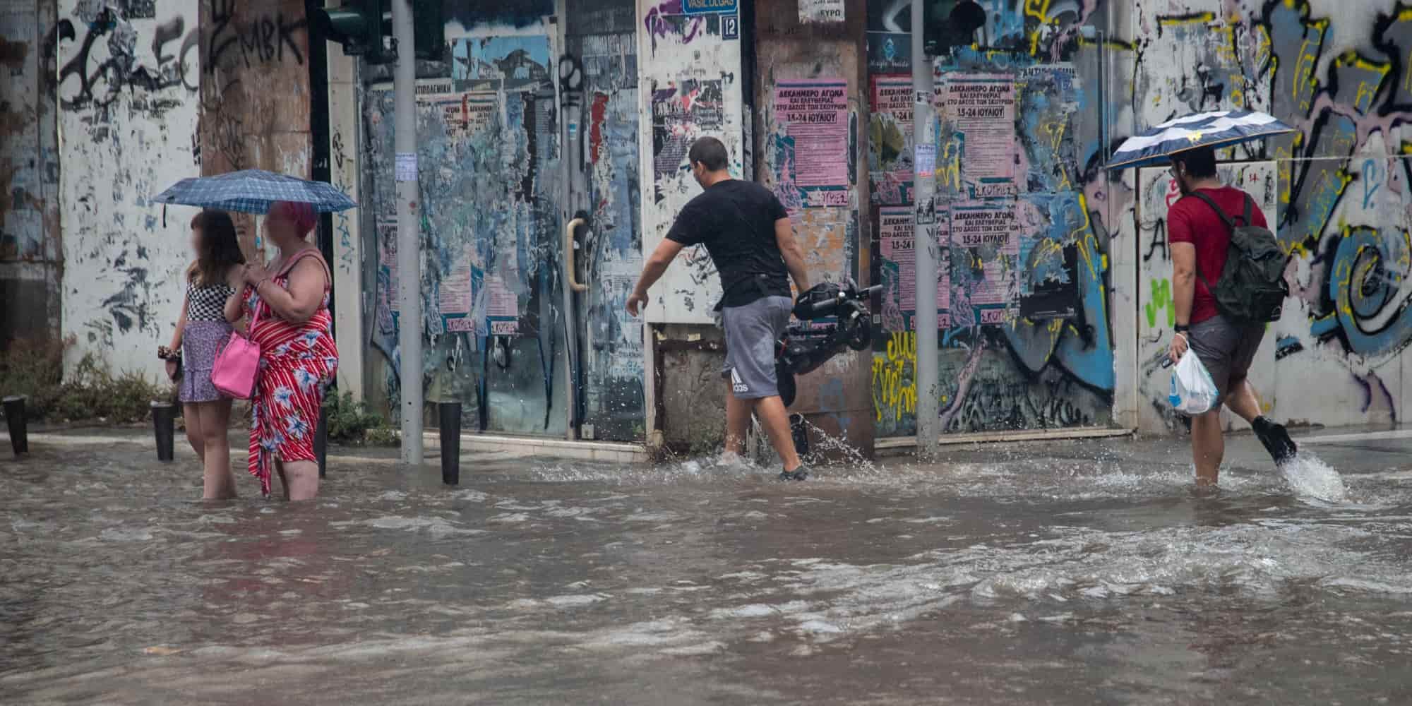 Άνθρωποι περπατούν σε πλημμυρισμένους δρόμους στην Θεσσαλονίκη μετά από καταιγίδα - καιρός
