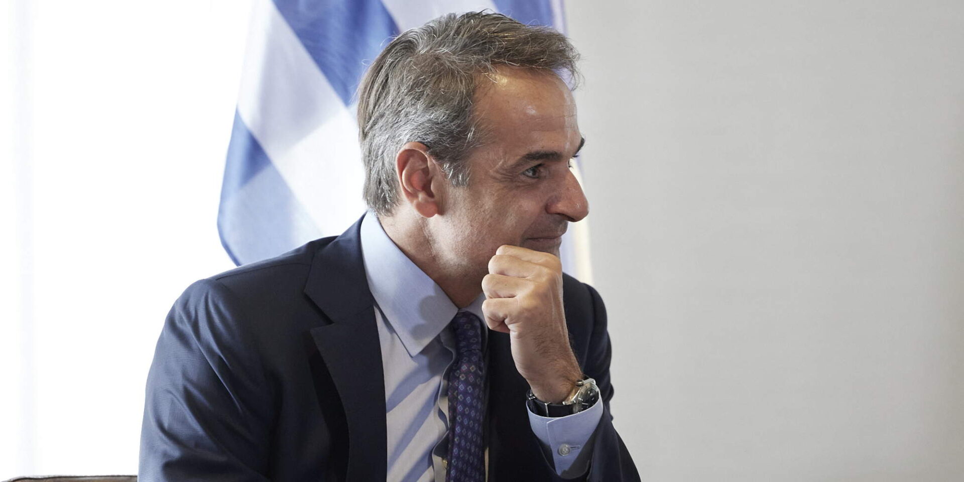 Ο Κυριάκος Μητσοτάκης μπροστά από μια ελληνική σημαία κατά τη διάρκεια των επαφών του στη Νέα Υόρκη