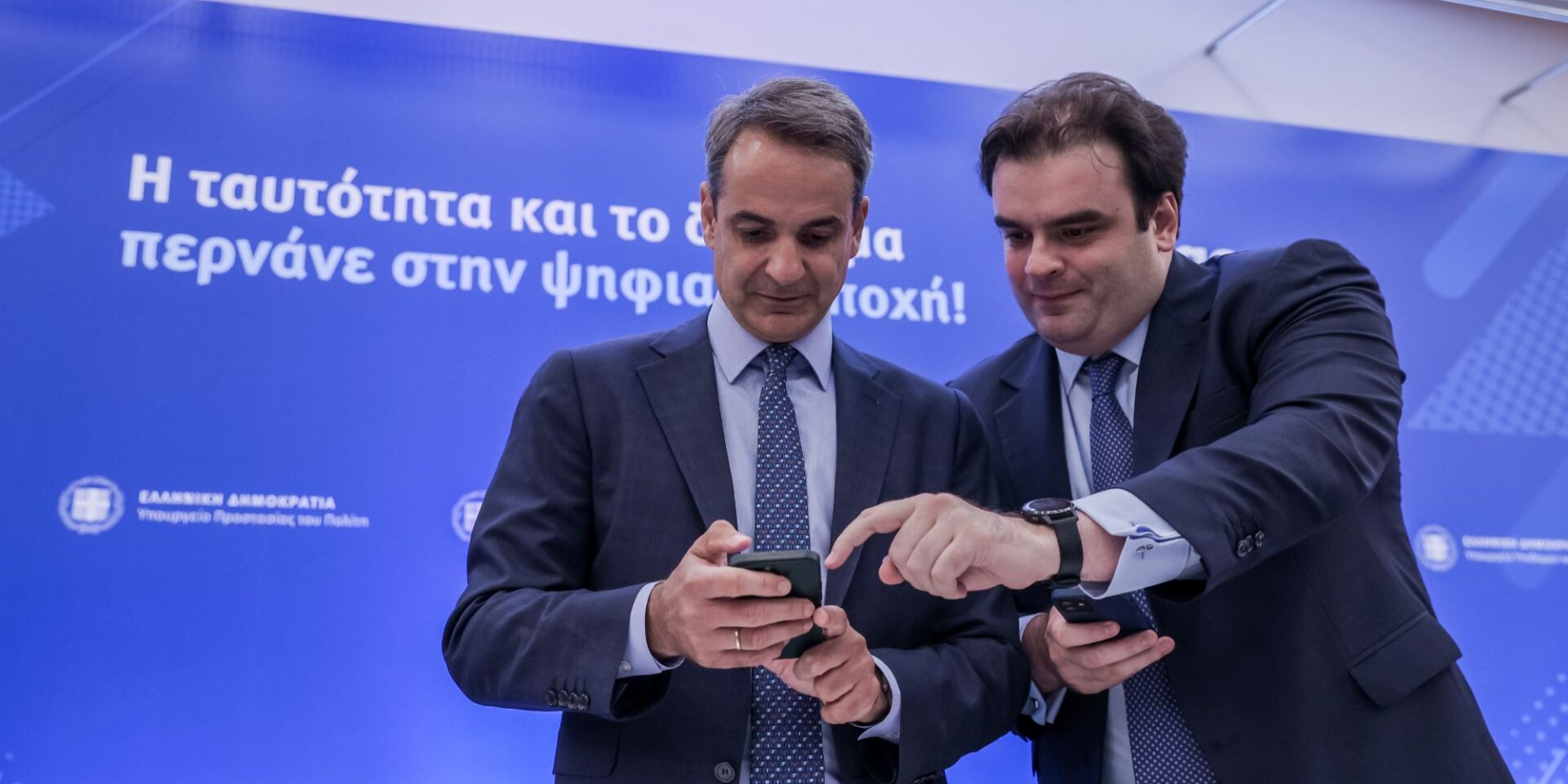 Ο Κυριάκος Πιερρακάκης και ο Κυριάκος Μητσοτάκης βλέπουν κινητό τηλέφωνο στην παρουσίαση του gov.gr