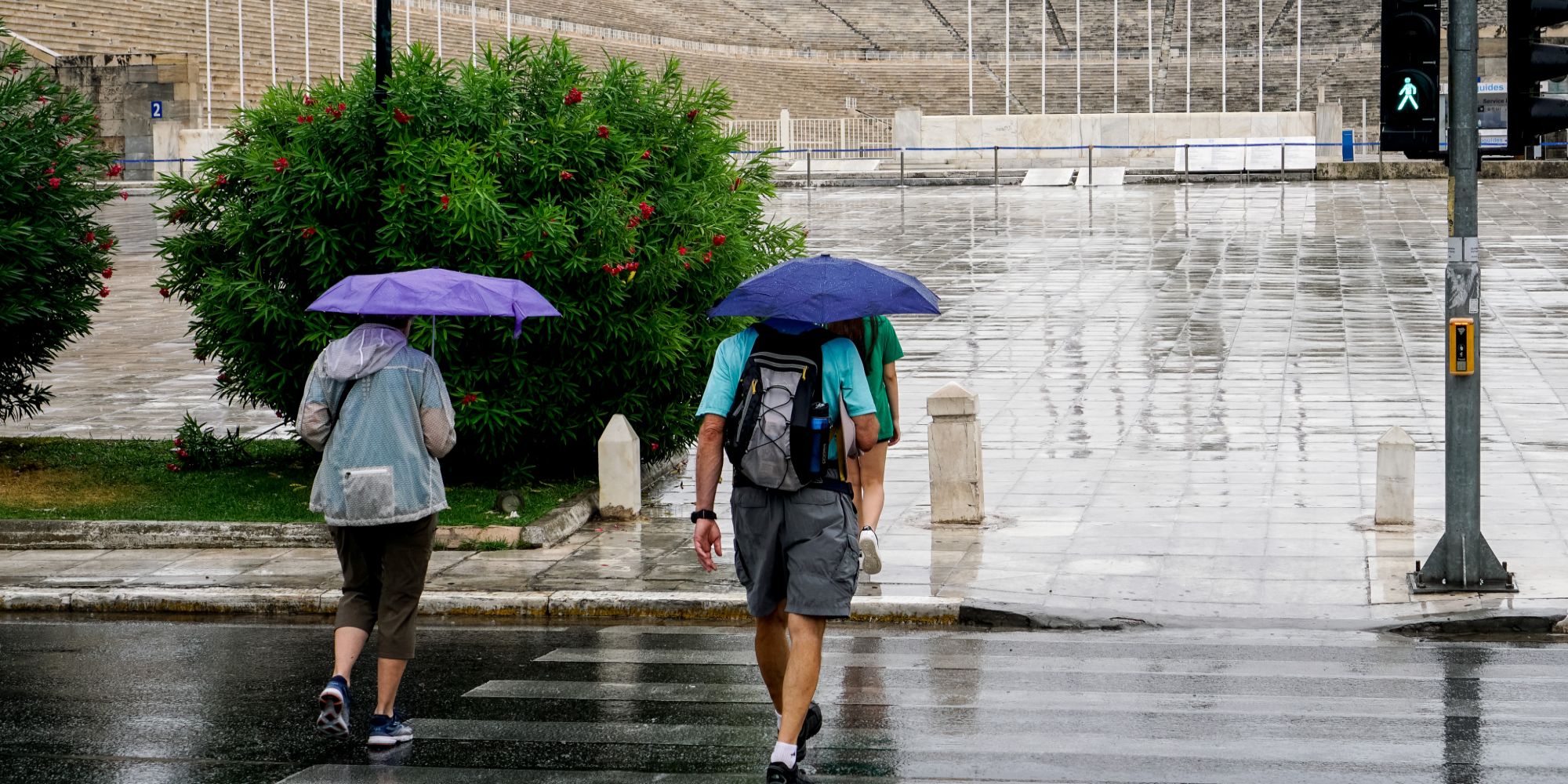 Πολίτες αντιμετωπίζουν την κακοκαιρία με ομπρέλες