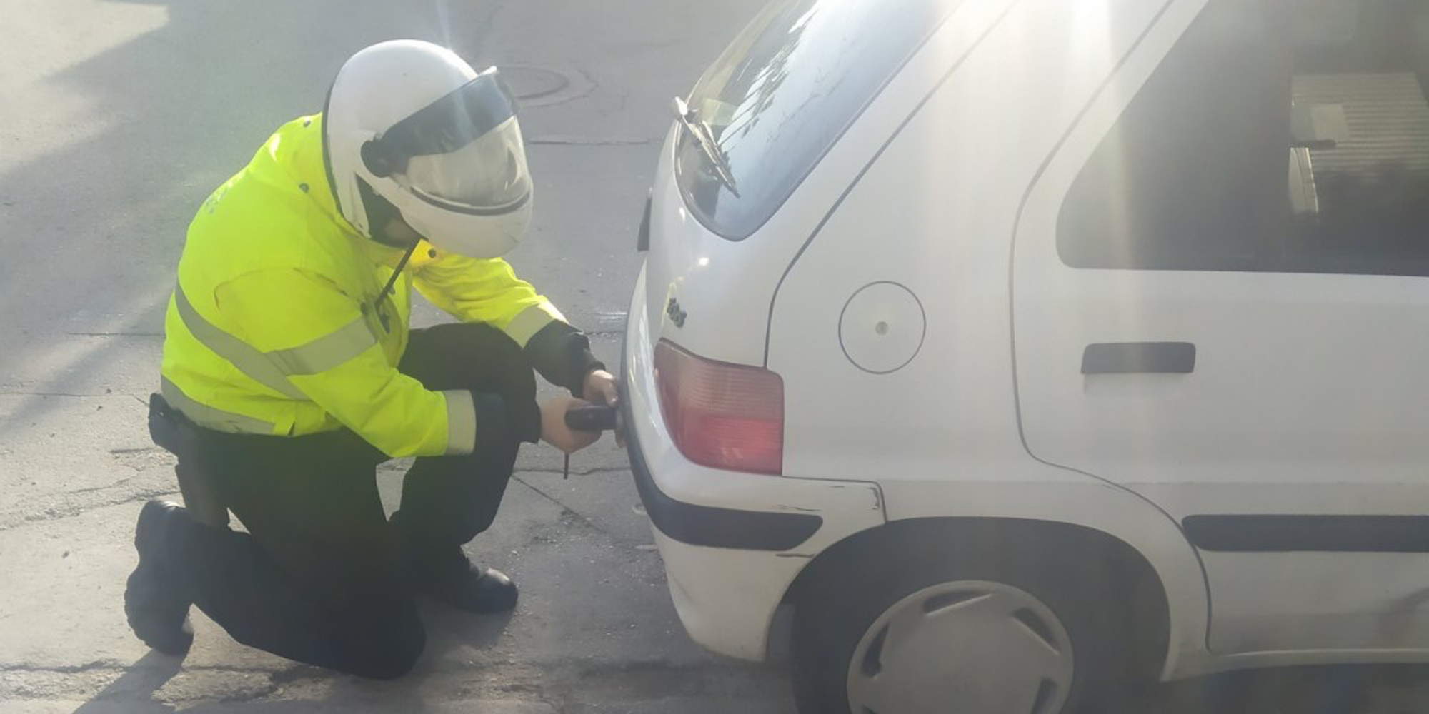 Αστυνομικός αφαιρεί πινακίδες από αυτοκίνητο παράνομα παρκαρισμένο