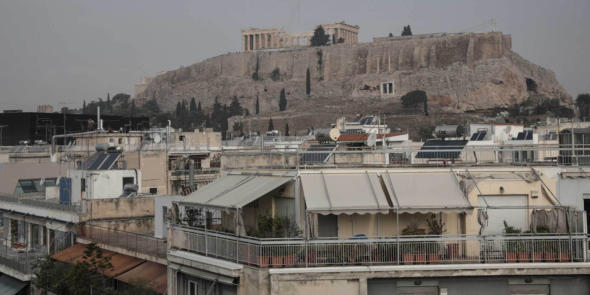 Σπίτια στην Αθήνα με φόντο τον Παρθενώνα
